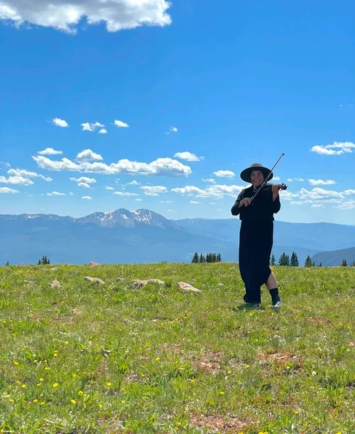 Violinist providing live music during a mountain elopement on a scenic Colorado peak