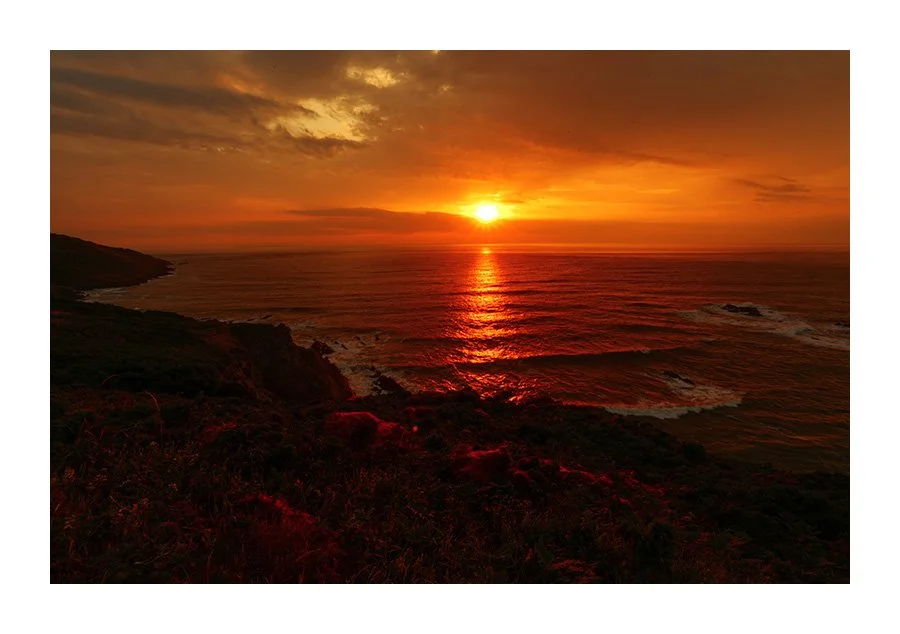 Sun Breaking Through Clouds at Sunset. Morthoe Devon