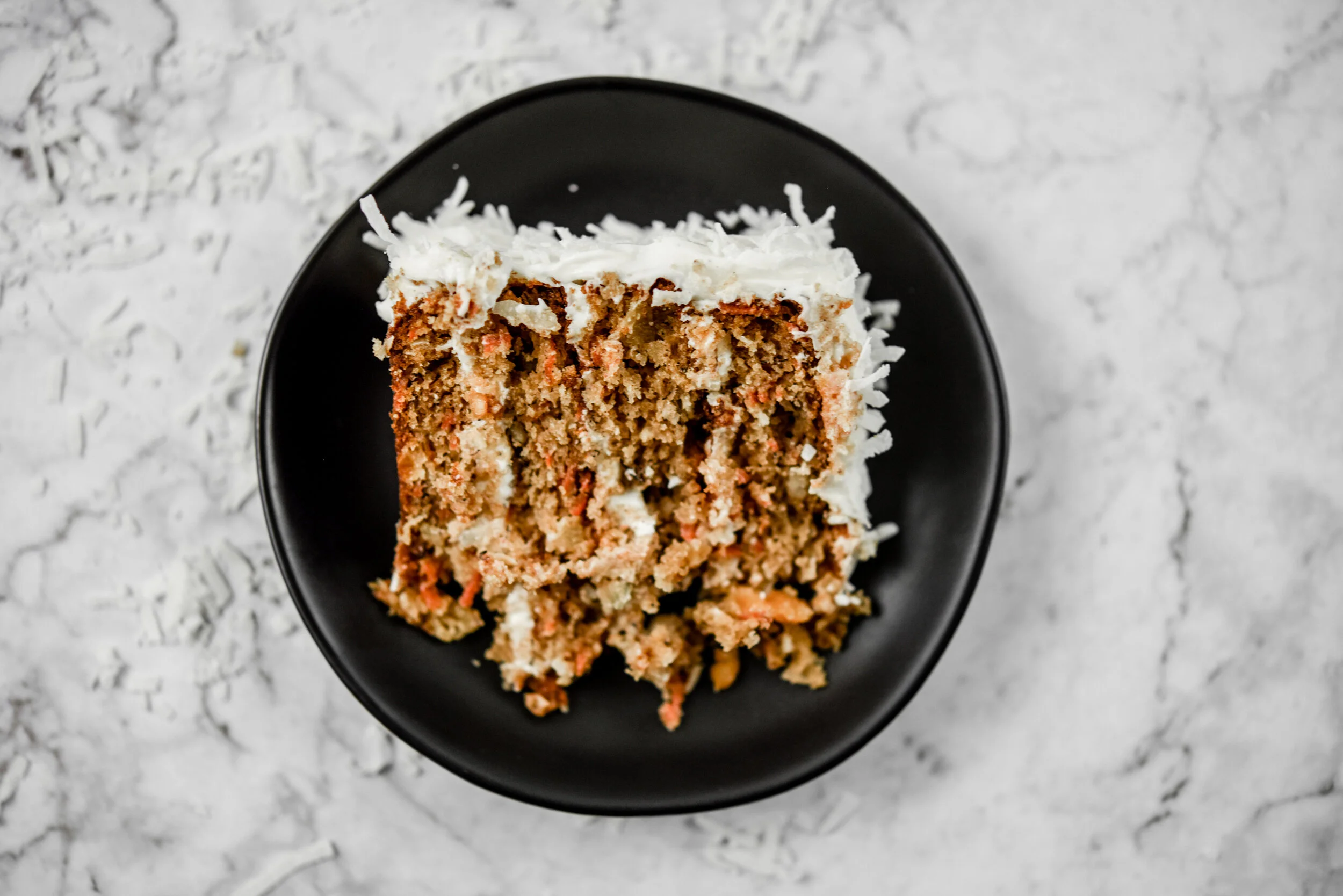 Thin layers of cake and thin layers of cream cheese icing keep this cake delectably moist. Food photography, food styling, and prop styling by Megan Crist.