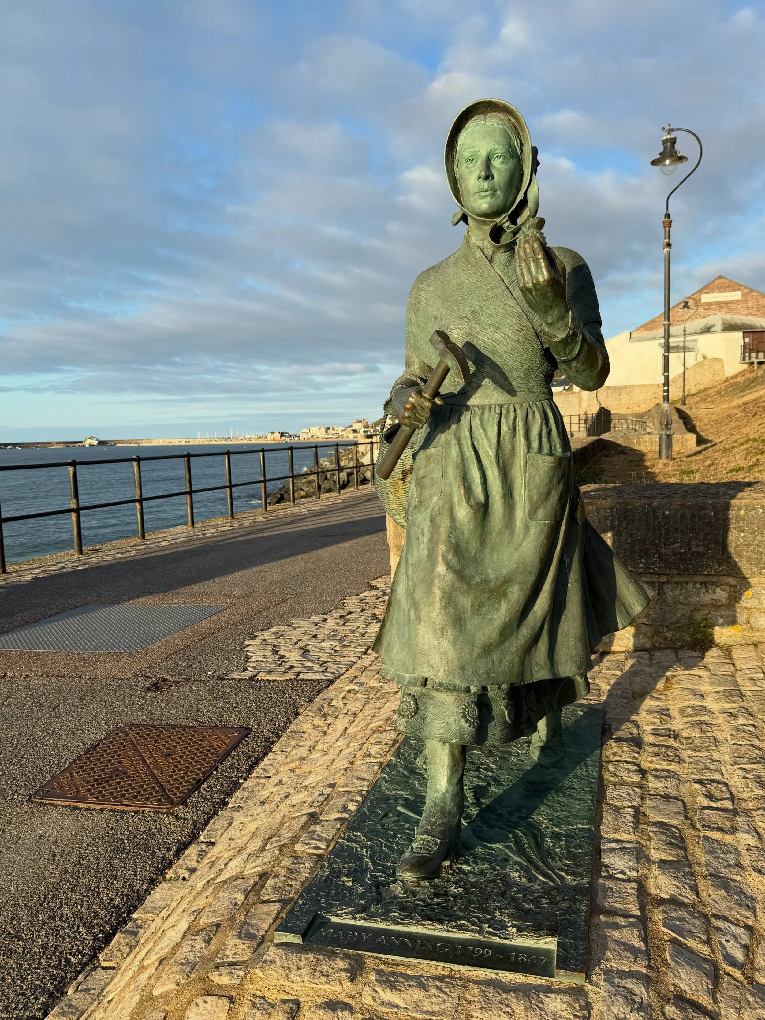 She strides purposefully along the esplanade, tools in hand, with her spaniel Tray at her heels. Her gaze is fixed on the cliffs where she discovered the fossilised skeleton of a Plesiosaurus that now hangs in the Natural History Museum. Despite disc