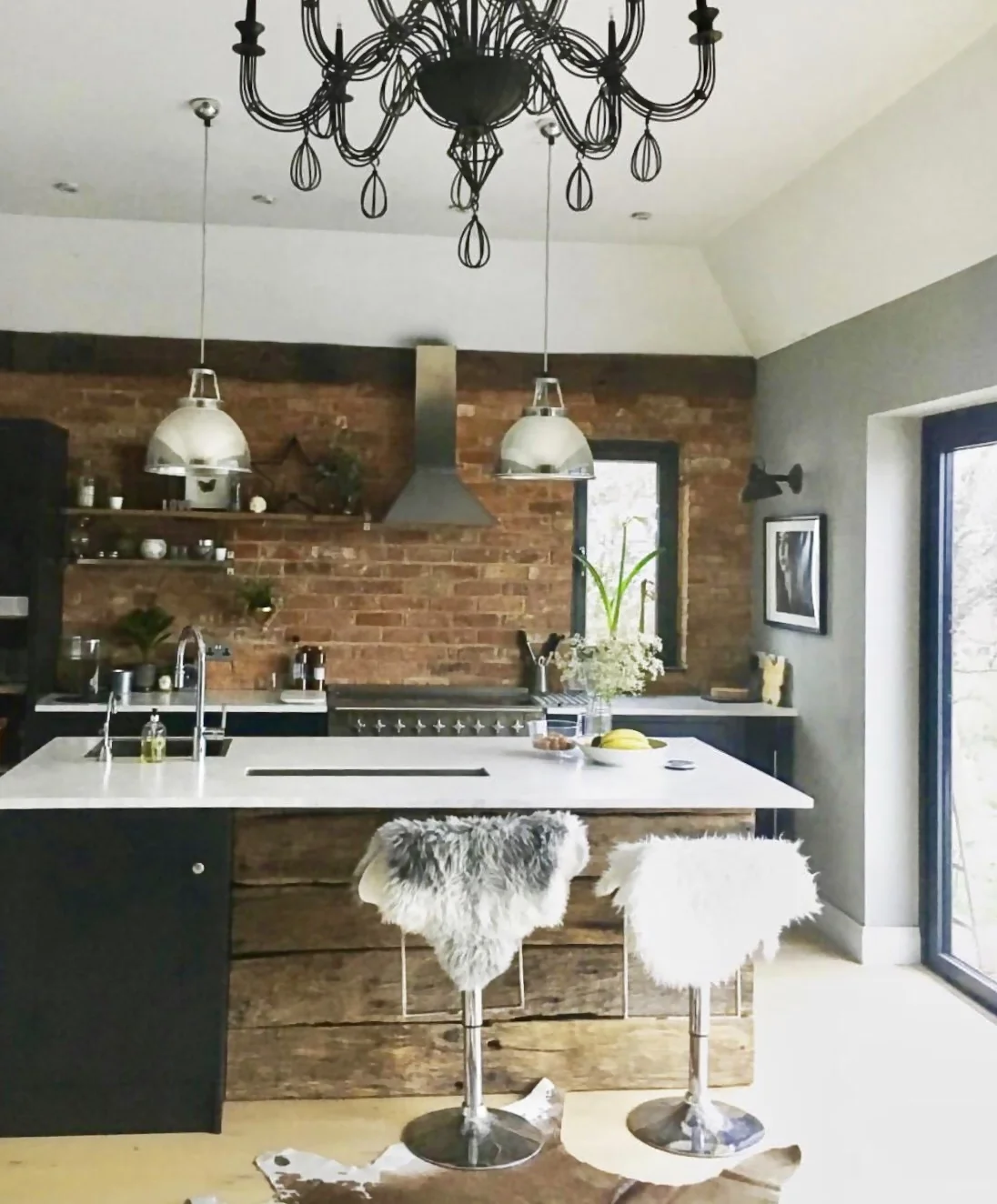 A kitchen photo from the early days of my Instagram...... We had to use what we had as we had no budget to buy anything else new for the kitchen so we spray painted a BHS chandelier black to go over the dining table and hid the white chrome stools with sheepskins.