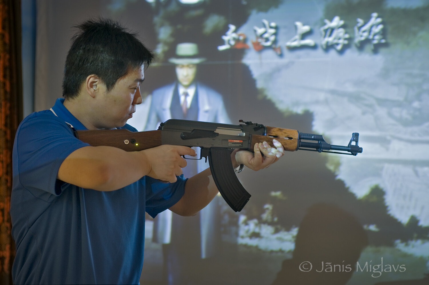 Tourist firing automatic weapon at virtual shooting gallery, Changyu AFIP winery.