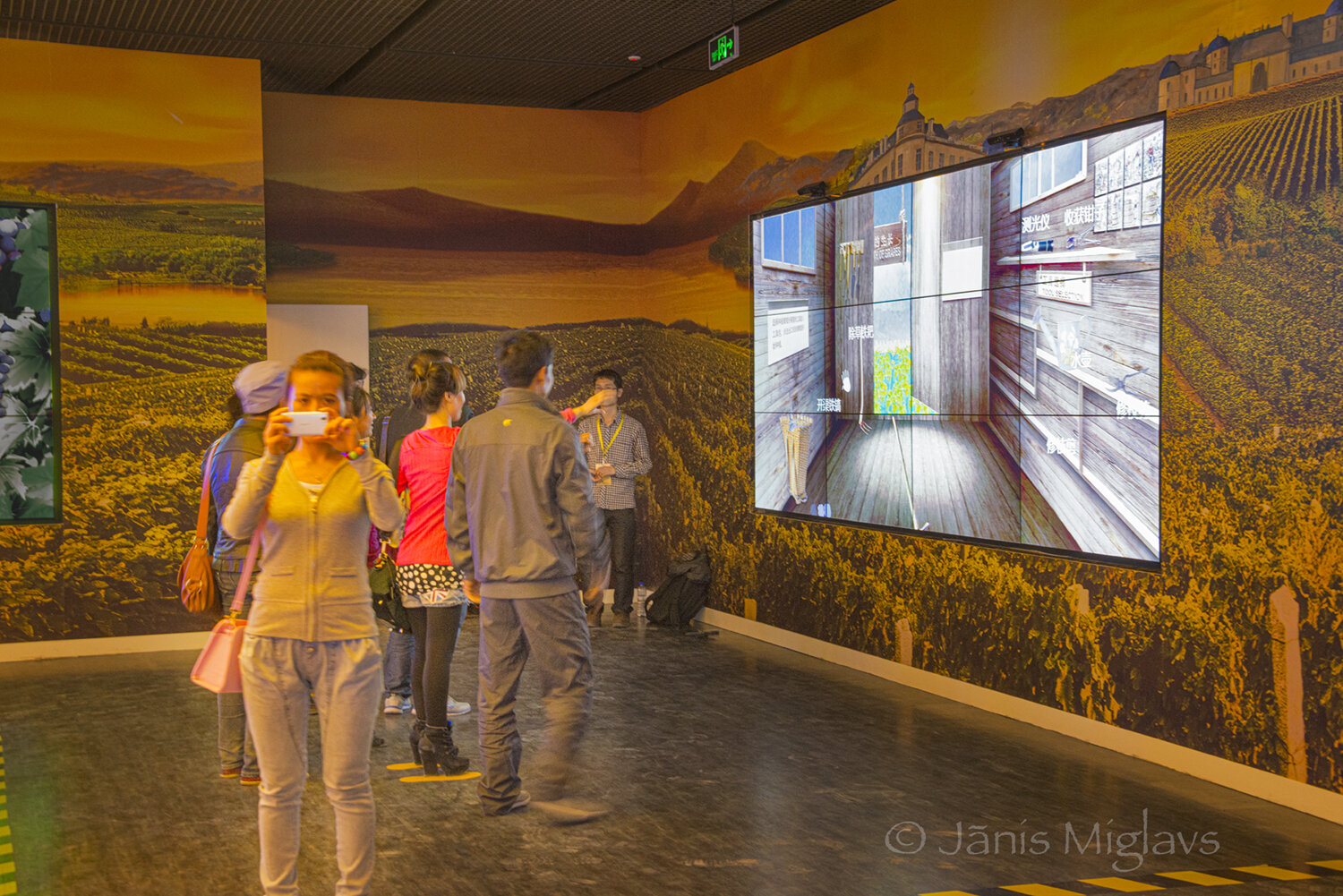 Chinese tourists play an interactive display while another visitor photographs the foreign photographer. 