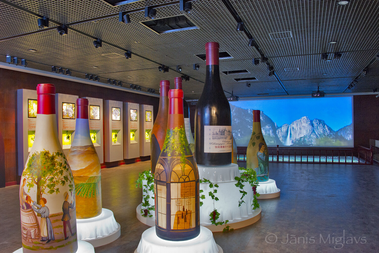 Hand painted people-sized wine bottles and pictures of Yosemite Falls are part of the Chateau Moser winery display area.