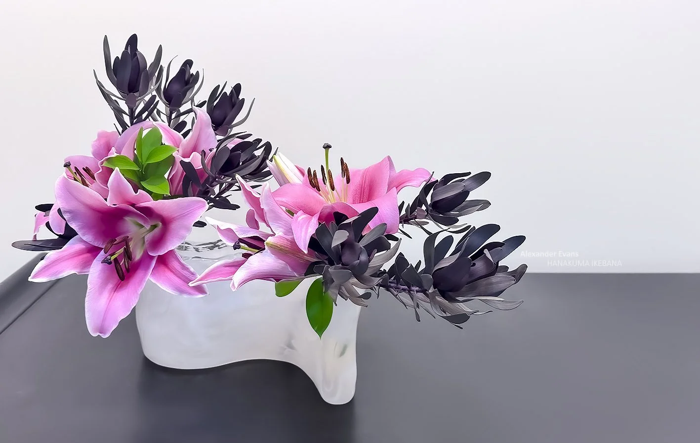 lilies and leucadendron in white glass wave container.jpg