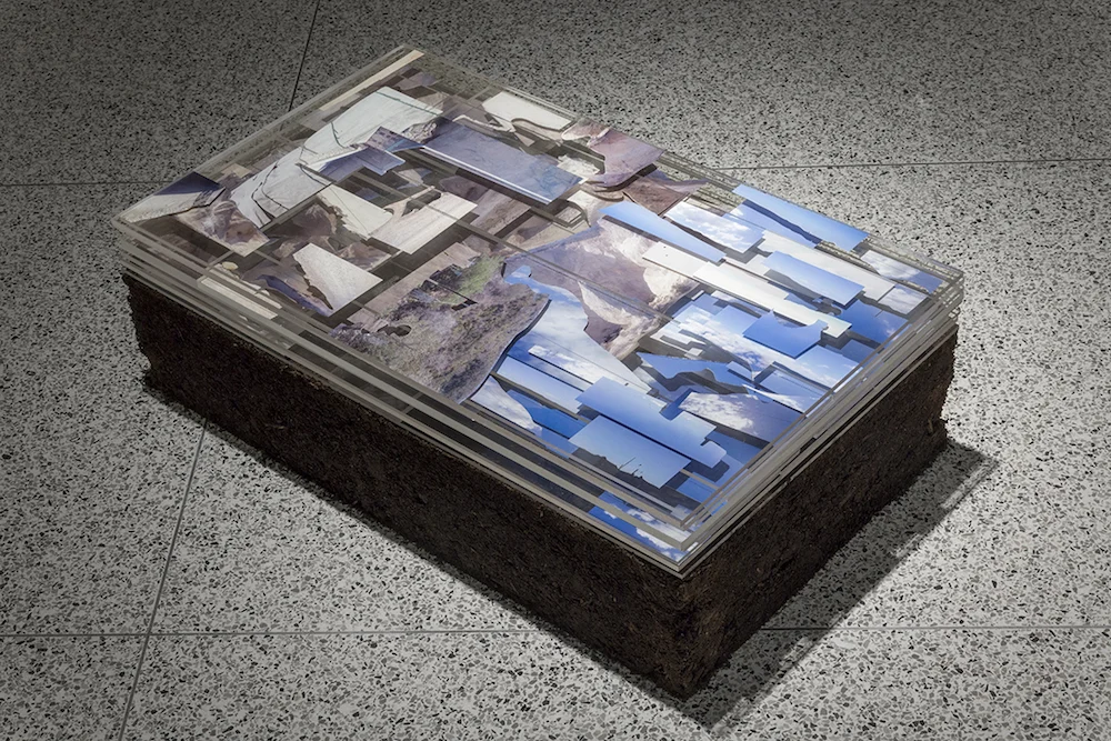 Jimaní/Malpasse , 2016 | Cut digital photographs from Haitian-Dominican borderlands layered in plexiglass on pedestal of rammed earth | Shirley Fiterman Art Center, New York City | Photo by Claudia Cortínez