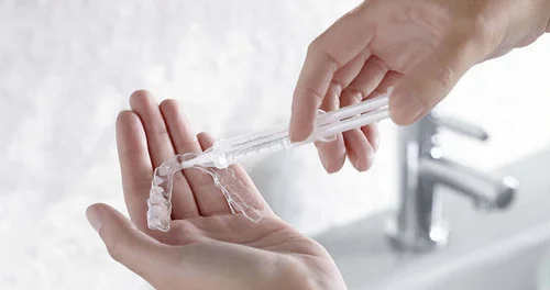 Patient filling their home teeth whitening trays with whitening gel