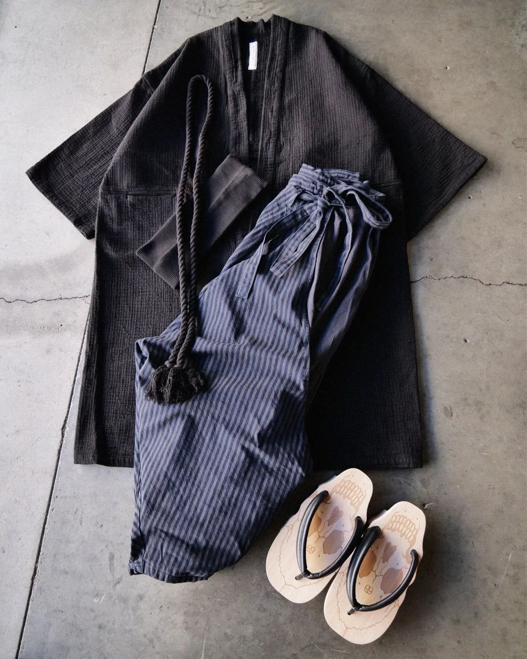 *Close Up Details

Jacket: Tsumu-Samurai-Black
Pants: Momota-Faded Black
Waistband: Haki-Black
Rope: Tsuna-Black
Sandals: Kuniyoshi Geta-Black

#prospectiveflow 
#mutsubypf 
#japanesedesigner