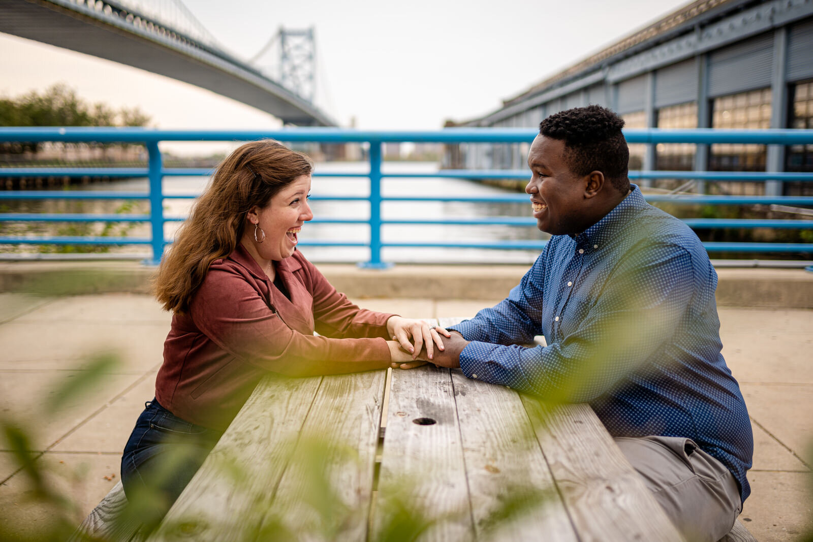 Two smiling people hold hands along the Philadelphia PA waterfront