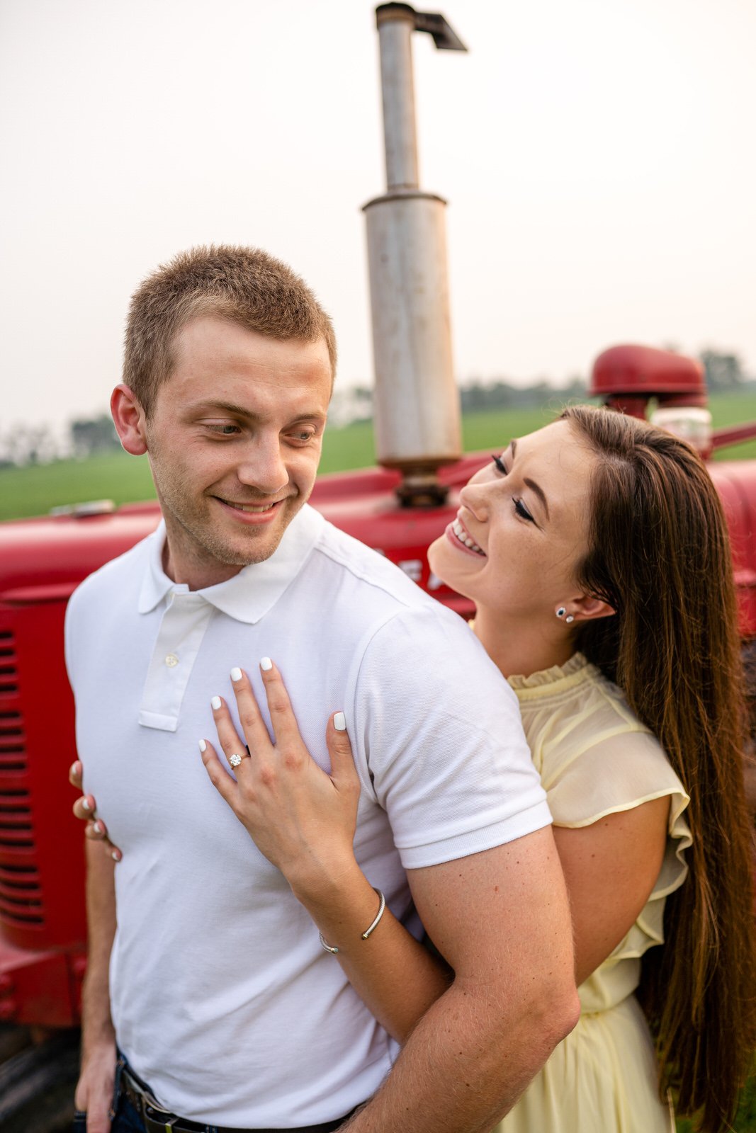 An engaged couple smile at each other on a farm in Elizabethtown PA