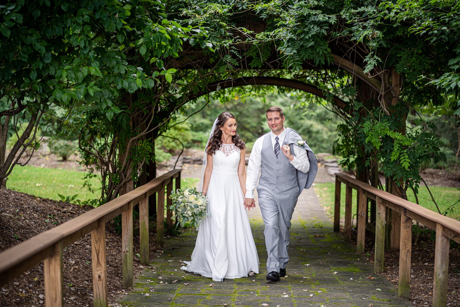 A well dressed newlywed couple walk in the woods at the Stroudsmoor Inn in Stroudsburg PA