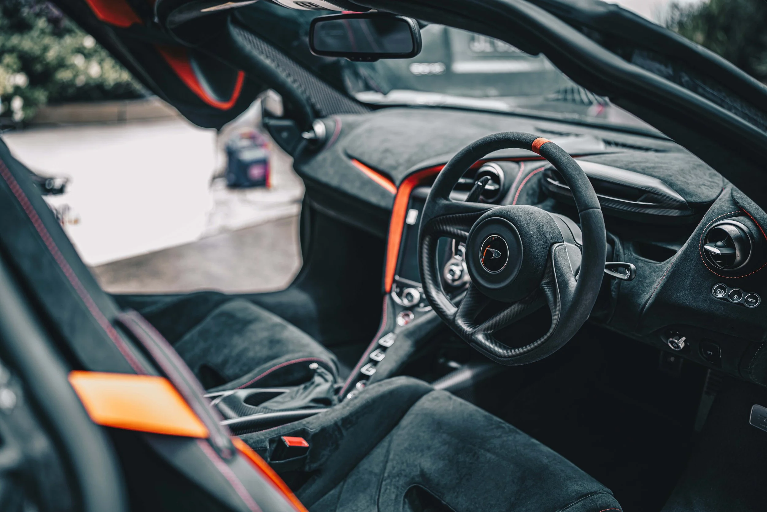 Shibbi Car Detail mobile car detailing performing a complete interior detail on a McLaren 765LT including vacuuming, leather cleaning, Alcantara upholstery care, dashboard cleaning, and steam cleaning in a customer's driveway in Point Piper, Sydney.