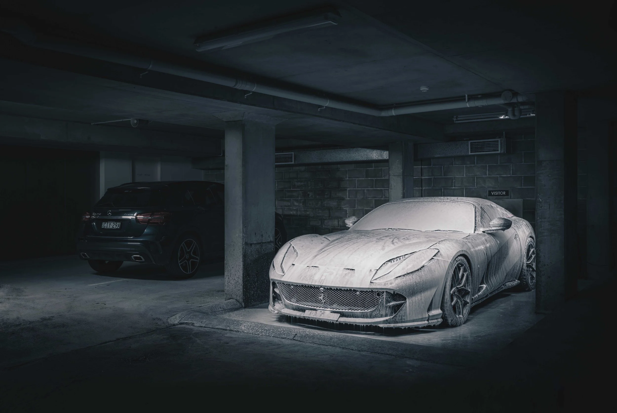 Ferrari 812 GTS completely enveloped in white snow foam during a scratch-free mobile hand wash. Foam pre-wash dwells before hand agitation to safely lift dirt. Mobile car wash servicing Rose Bay / Macquarie Park by Shibbi Automotive Care.