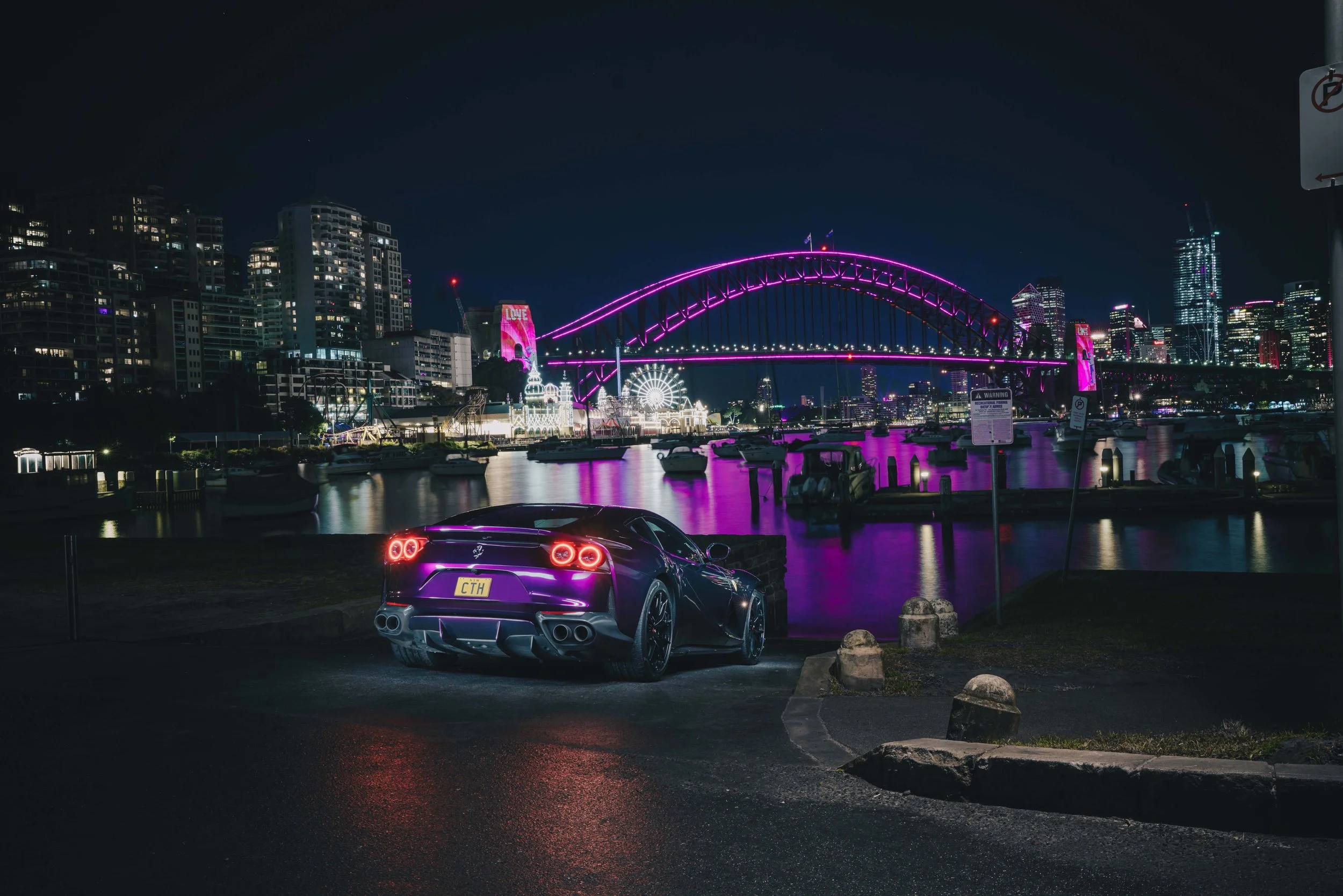 Purple Ferrari 812 Superfast glowing under city lights during a professional night photoshoot in Sydney Harbour. Shibbi Automotive Photography. Mobile car wash servicing Eastern suburbs and northern sydney area.