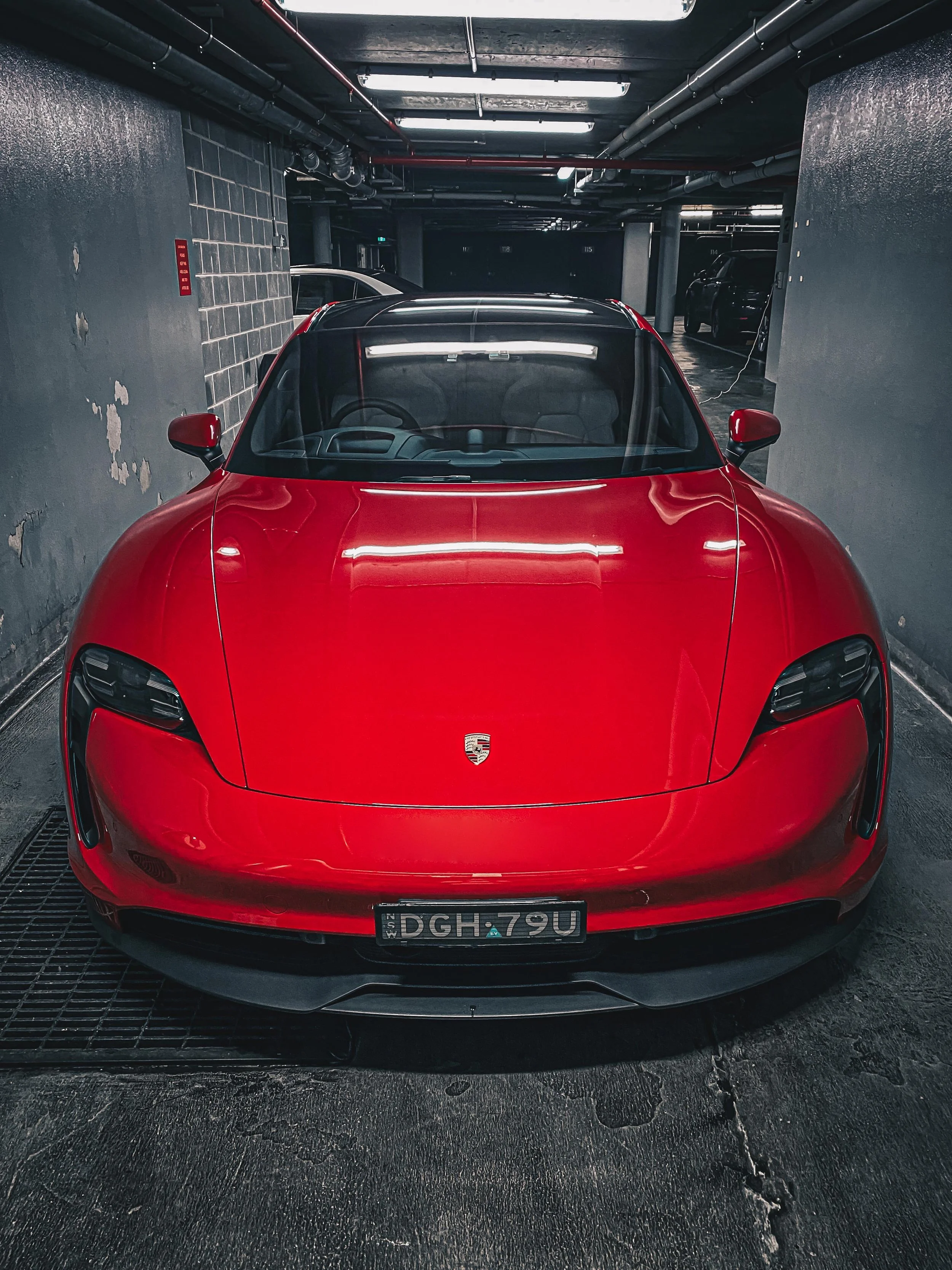 Glossy red Porsche Taycan Sport parked in Pyrmont after Gyeon Q2 Pure ceramic coating application. Deep reflection, hydrophobic finish, and showroom shine achieved by Shibbi Automotive Care mobile detailing. Servicing Rose Bay / Macquarie Park area