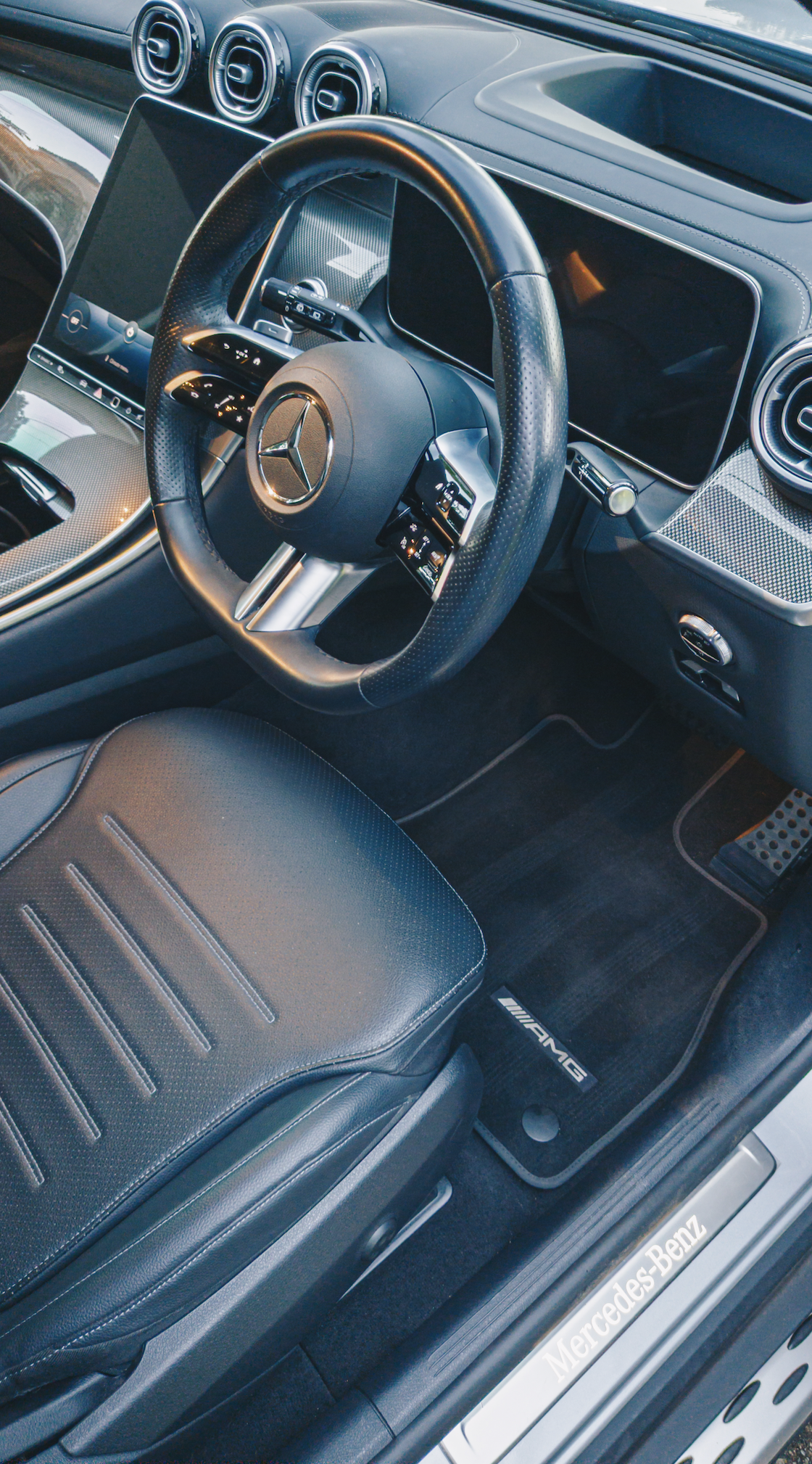 Shibbi Car Detail mobile car detailing performing a complete interior detail on a Mercedes‑Benz AMG including vacuuming, leather cleaning, carbon fiber trim polishing, MBUX screen cleaning, and steam cleaning in a customer's driveway in Bellevue Hill