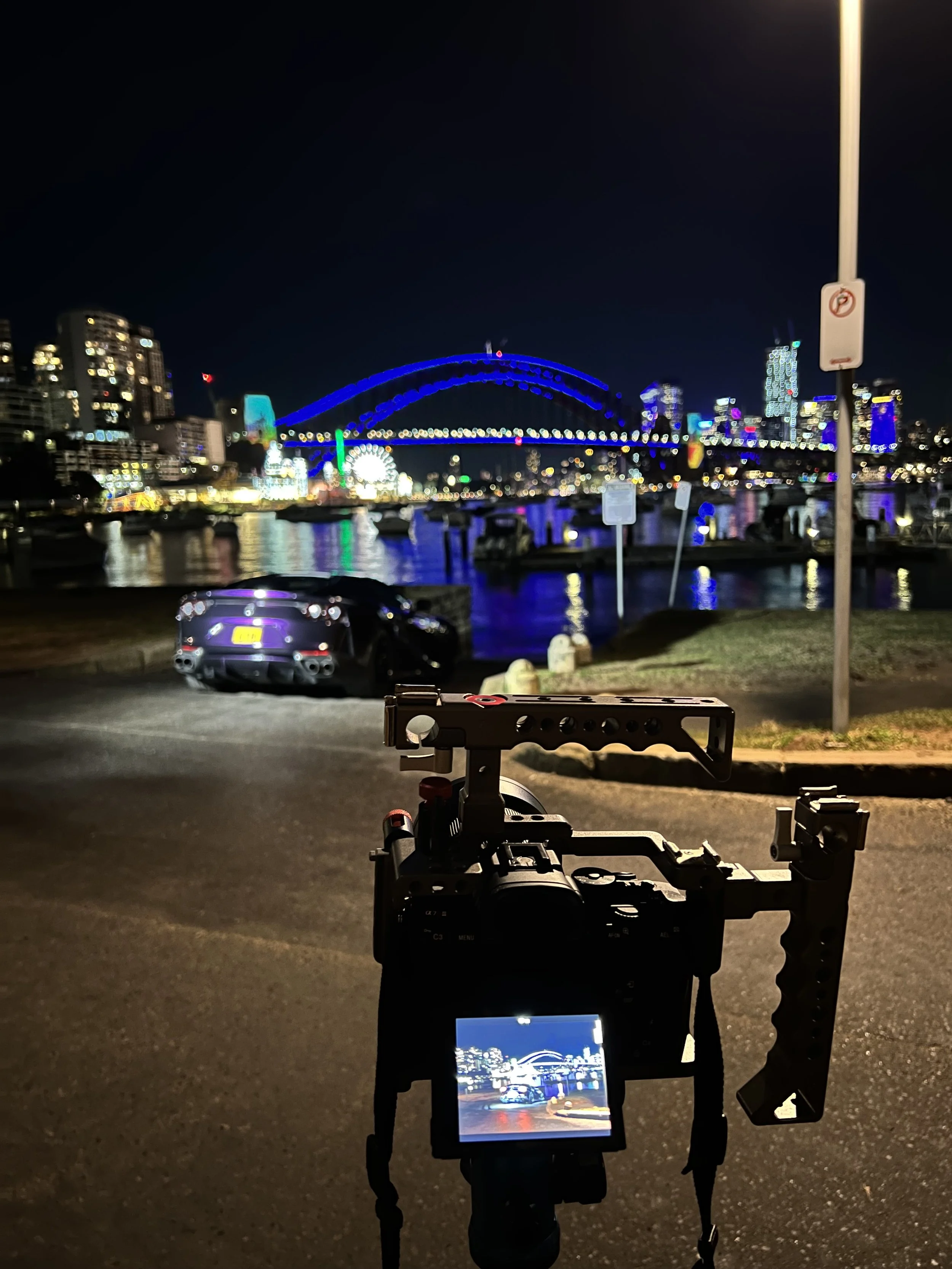 Purple Ferrari 812 Superfast glowing under city lights during a professional night photoshoot in Sydney Harbour. Deep reflections, dramatic shadows, and exotic curves captured after mobile car wash by Shibbi Automotive Care.