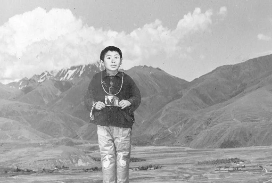 Eight-year-old Lelung Rinpoche, holding a photograph of his uncle. At age 12, Rinpoche began studying at Drepung Monastery in India on the advice of Ling Rinpoche