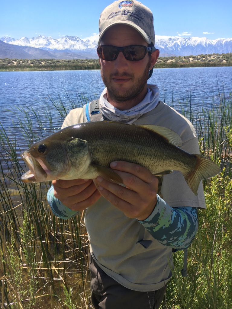 Alaska fly fishing guide Tyler Smith with a nice bass caught with a fly rod from the shores of Buckley Ponds.