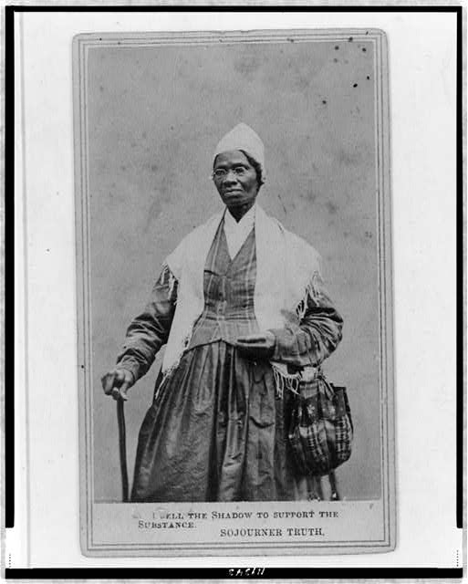 Sojourner Truth, three-quarter length portrait, standing, wearing spectacles, shawl, and peaked cap, right hand resting on cane