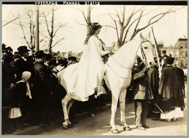 Inez Milholland Boissevain, wearing white cape, seated on white horse at the National American Woman Suffrage Association parade, March 3, 1913, Washington, D.C.