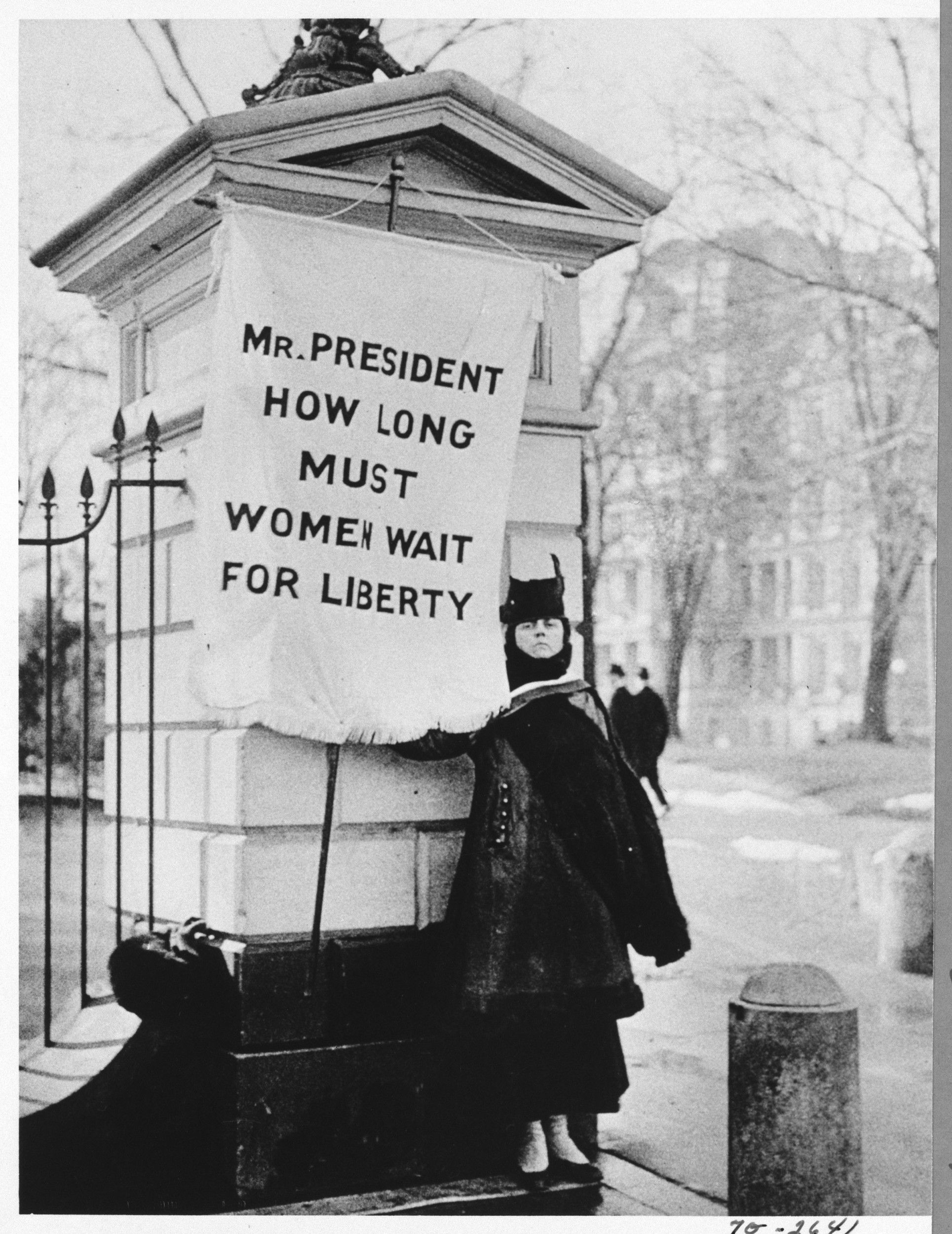   Flag Bearer for Women's Rights Standing Near White House  
