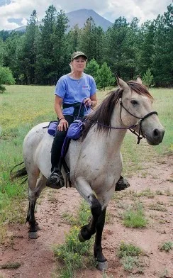 Ginger rides Sax, Cloud's brother, near her ranch below Gibbs Peak in the Sangre de Cristo Mountains of southern Colorado. Sax was removed in 2009 from his Pryor Mountain home and is co-owned by Ginger Kathrens and Ann Evans. Photo by Nadja Hallstrom