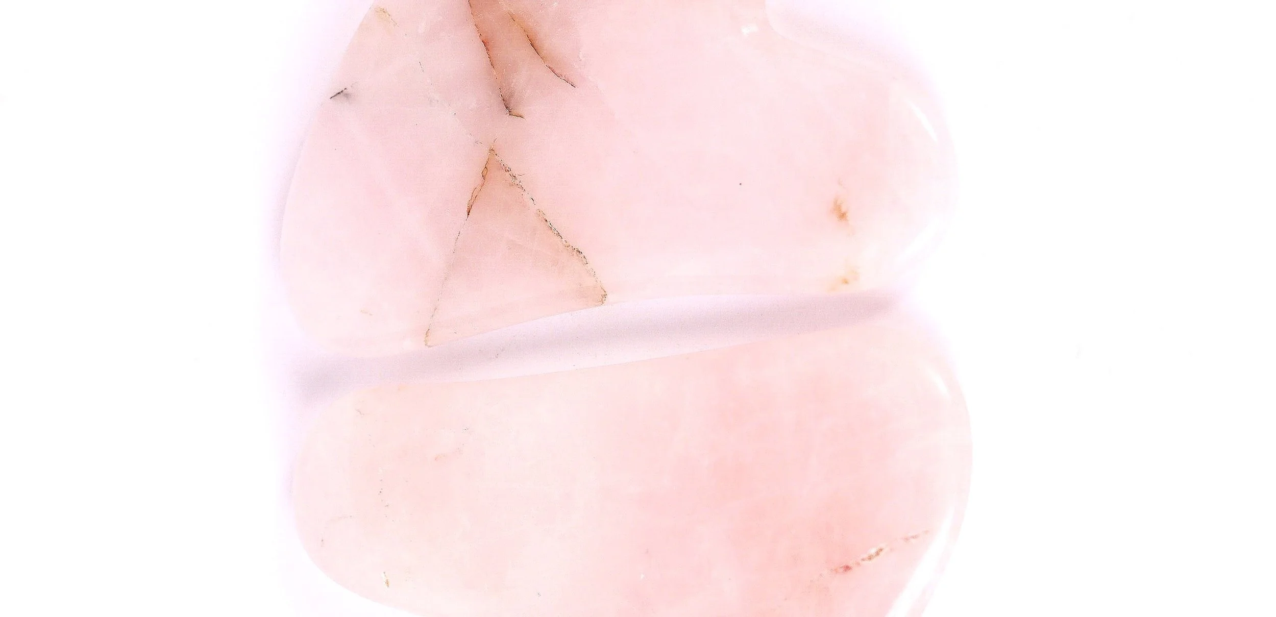 Gua Sha en quartz rose sur un fond blanc