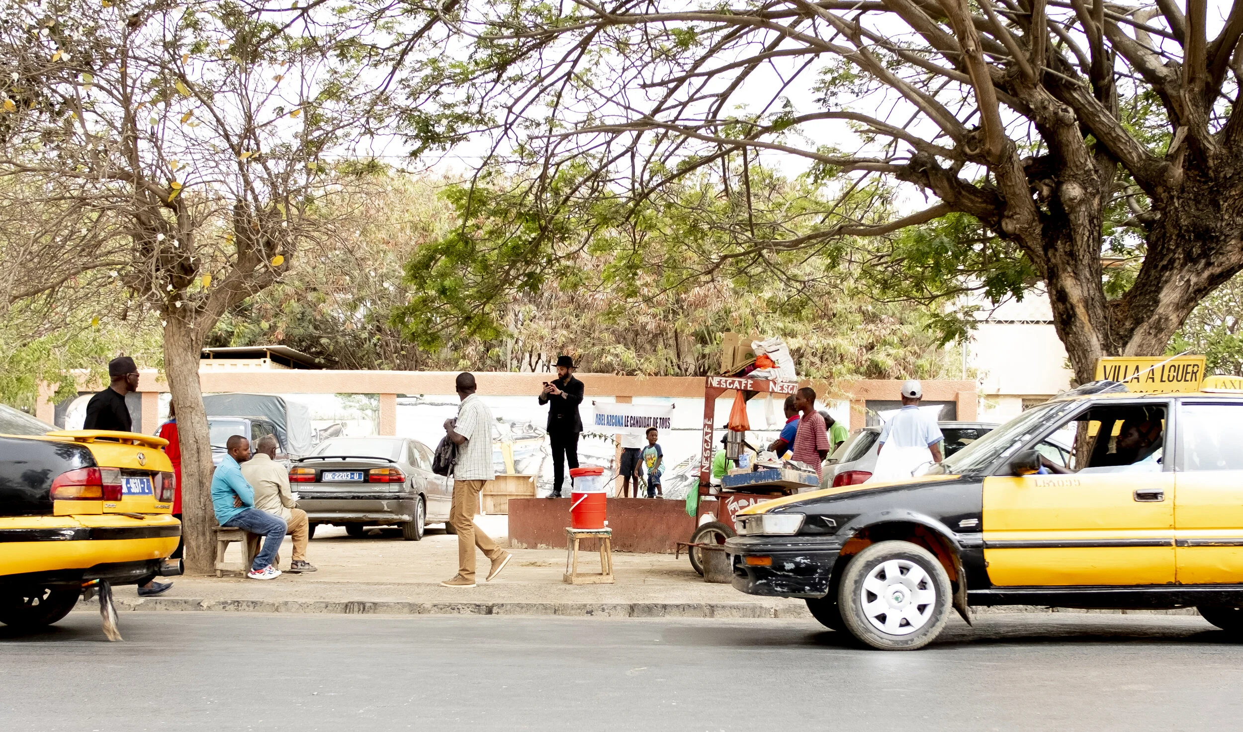 Azcona in the center of Dakar activating a hate speech filled with microracisms and using falsely integrating phrases commonly used by far-right leaders such as Marine Le Pen or Santiago Abascal from a colonialist position. / Azcona en el centro de Dakar activando un discurso de odio impregnado de microracismos desde una postura colonialista utilizando frases falsamente integradoras empleadas habitualmente por lideres de ultraderecha como Marine Le Pen o Santiago Abascal.