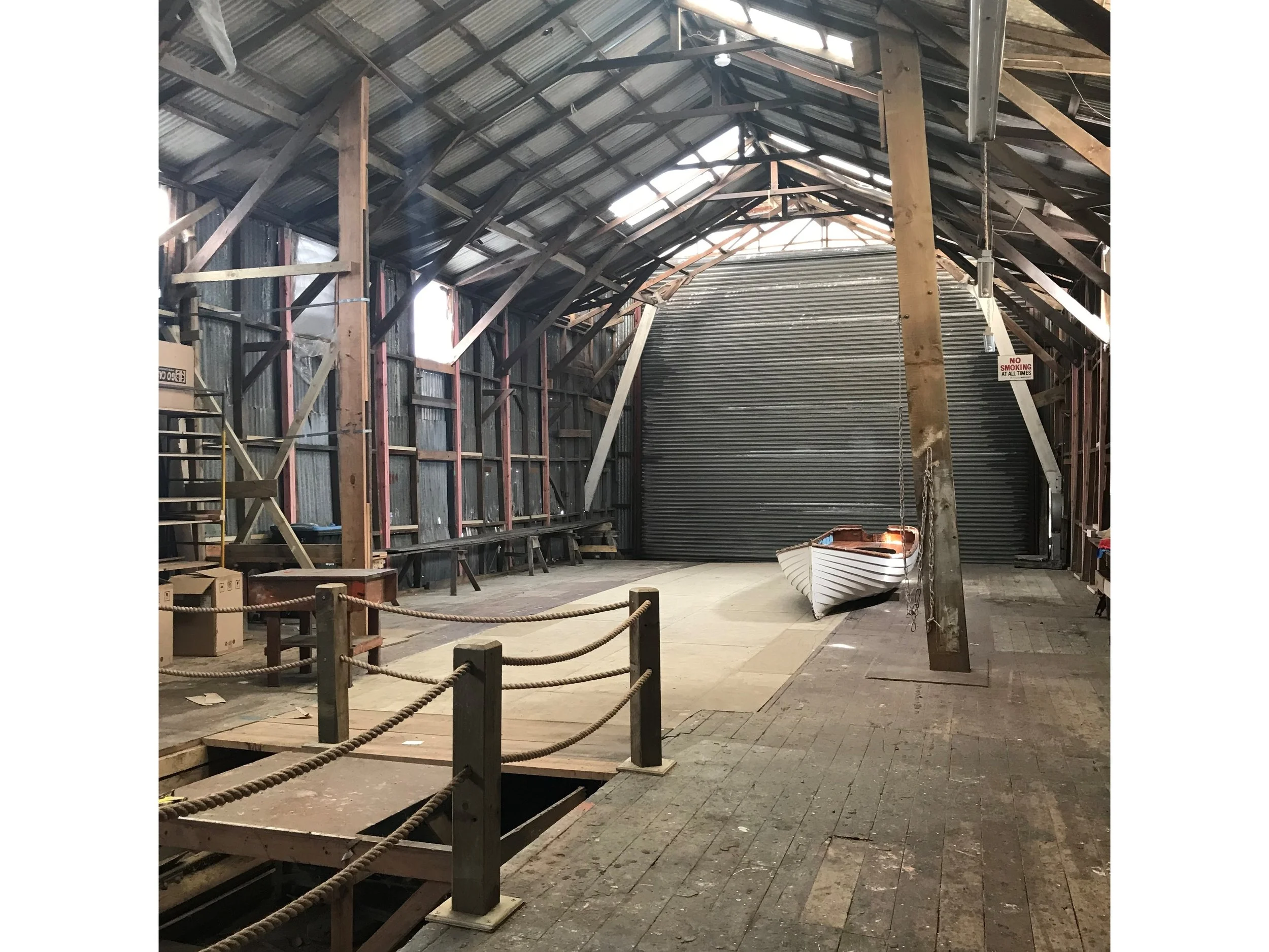 Yet one special, not so well-known, maritime project where restoration work has just begun is close to his heart. Rod Marler is so passionate about the Vos boatyard, he is eyeing it up for his own office when it’s finished in the summer of 2018. But then, he concurs, so might half of creative Auckland. And most likely too, it will be THE place for events and functions, especially when the America’s Cup boats arrive in New Zealand. The Vos wooden boat shed and slipway reaches into the water on reclaimed land in Hamer Street at the edge of Wynyard Wharf. As Auckland’s last remaining wooden boatyard, it’s unique. All of Auckland’s commercial fleet was built there, as were some of New Zealand’s most well-known racing boats. Masts were still being made in the shed until comparatively recently up until the 1980s. By sheer luck, it has not been demolished. Unlike much else original from this industrial maritime era, apart from the Silos and the Jack Tarr shed, which was used for drying sails. The Vos boatyard was established in the 1930s by the enormously skilled and entrepreneurial Percy Vos, who forged his business Vos & Brijs Boats, against the odds and created one of the best known and most successful boat building brands in the country. Vos was one of the early greats of New Zealand’s marine industry, a trail blazer for future tradesmen and business owners. Not only was he renowned for the quality of his boats - from large ferries and tugs to pleasure craft, yachts and dinghies - but he was also a brilliant businessman. A sartorial gentleman with high standards in a cut-throat world, he was highly respected by all who came into contact with him. Marler doesn’t mince words; “It’s a rumpty old building, he says. “But it oozes charm and personality.” With a soaring skeletal timber structure that resembles the upturned hull of a boat, it’s a cool character space with a brimey industrial atmosphere that transports you back to the days when the area bustled with maritime activity. The old tracks to the water from the slipway, platforms, the old furnace for bending timber, pulleys and the original motor that pulled up the boats, they’re all still intact. And thankfully, a maritime engineer who has inspected the site says it won’t take much effort to get eveything operable again. Marler is clearly enthralled with the boatyard, now owned by Panuku, and the possibilities it offers for the future. “You get the same kind of feeling you get as when you walk into a mediaeval church. You go in there and you can almost smell the guys working there. There’s the coal tar and the wood. It’s incredible, like a snapshot in time, almost like the men have just dropped their tools and walked out. “You can tell people about it. But when they walk in, they go, ‘now we get it’. You open the big sliding door at the end, look down the slipway to the water out to the west and it’s just amazing.” Marler who grew up in St Mary’s Bay remembers the Vos boat shed at the bottom of his garden and seeing his own family boat being worked on there. “I used to wander down and explore that whole area as a young fella. It was incredibly dangerous but wonderful.” The project has been around five or six years from the time when Panuku was Waterfront Development Auckland. “Waterfront Development held it out as a very special place; a bit of a treasure. But there was never any money to do anything with it. “The Percy Vos Charitable Trust was formed around 2012 by a group of passionate people who just wanted to preserve this place without doing too much to it. “Making it safe and useable as a working wooden boat slipway, was always their vision. Buildings are best used. We want to keep work on it minimal and not destroy all the good stuff that makes it special.” Once it’s completed, the only modern part will be the kitchen facility for functions, bathrooms and things like the glass doors, fitted so observers can walk past and look inside at craftspeople working on the old boats. Even the old iron cladding will be replaced by used corrugated iron from demolition yards. “The Trust set themselves up to lobby Waterfront to support the project, which we did,” says Marler. “Then we had a design done by architects Fearon Hay and used it to convince Council to get money from the Built Heritage Fund to get the project underway.” Panuku has already held a couple of functions there but since the project director Villy Kotze got involved with conservation architects Matthews & Matthews, they discovered old asbestos cladding needed to be scraped away before starting the restoration. $2.5 million worth of funding will facilitate stage one which involves making the boatshed building compliant and structurally sound, to a state where it can be occupied as a usable function space with tenants as well – both of which will provide funding for further work. As more funding becomes available and the leases make it possible, stage two will get the slipway up and running so Panuku can get classic wooden boats in there to be worked on. The idea is for the space to be as interactive as possible. To make it happen, Panuku is keen to keep the Trust operating, because most of the members are or know classic boat owners. “There’s a good interface there,” says Marler. “They were very active in the early days.” Concept designs are ready to go and from there, the project will step into the detailed design phase then work will begin. Kotze estimates the first stage will take around eight months and the whole project will be completed next summer. The cavernous space will be compliant for around 150 people. As there is nothing else like it in Auckland, it will be a unique venue and a major tourist drawcard. The Vos shed will also be a fitting memorial to Percy Vos, who no doubt would appreciate the dedication he has inspired for a major restoration that has been a long in the making. The boatyard will sit alongside a contemporary shipbuilding space owned by Sanford Limited, the fishing company, providing an elegant contrast between the character-filled original and the sophistication of the new. 