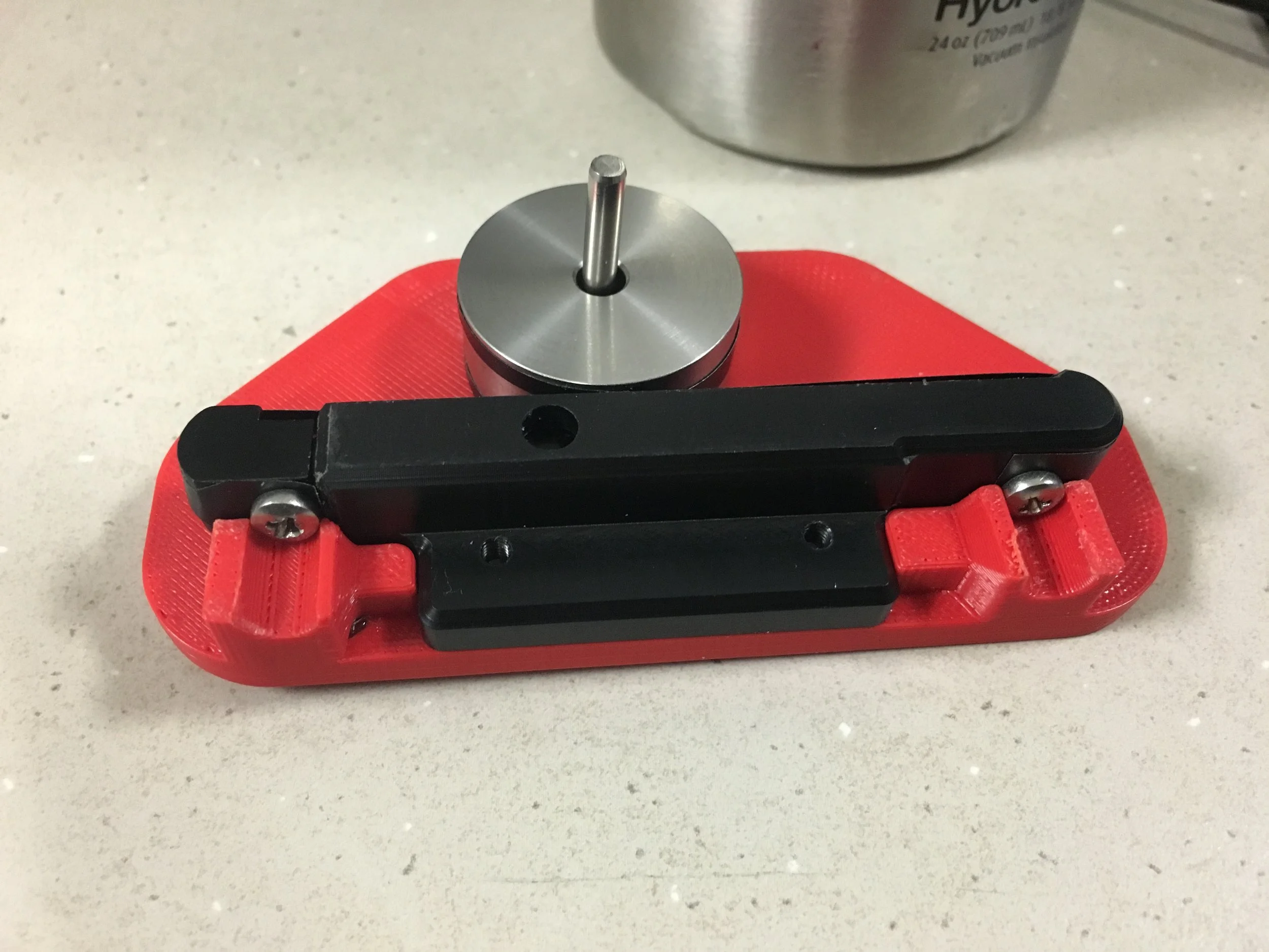  This project was a two-fold and involved redesigning the band of steel that wraps around the silver disk. The band was too thin of steel and the edges had a tendency to catch on each other, and the bands would break.  The new redesigned spring with 