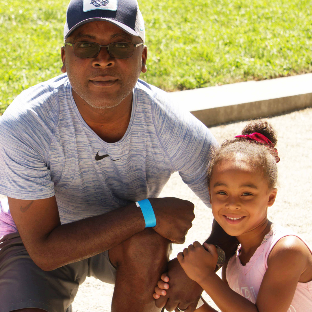 Father and daughter pose for camera at event