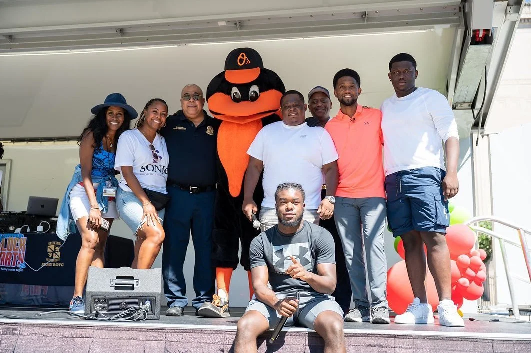 Image of Back to School attendees posing with Orioles mascot
