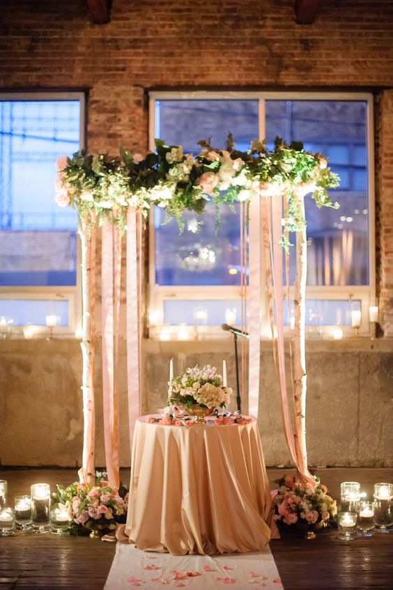 Candles, birch and flowers warm a winters wedding sweetheart table.