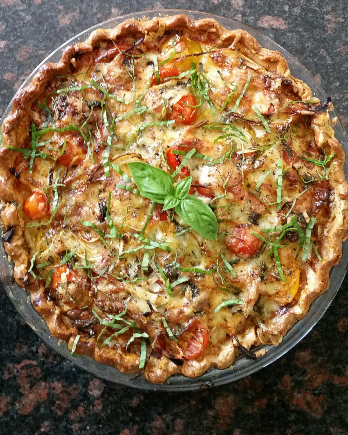 Yummy tomato pie topped with fresh basil.