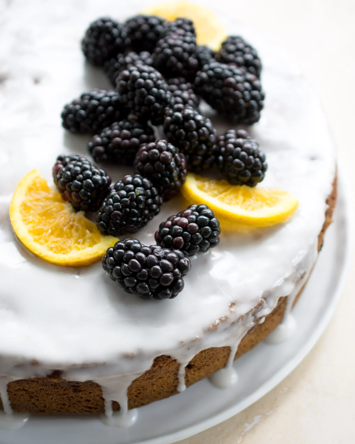 Just glazed orange blackberry cake. Garnished with fresh blackberries and orange slices.