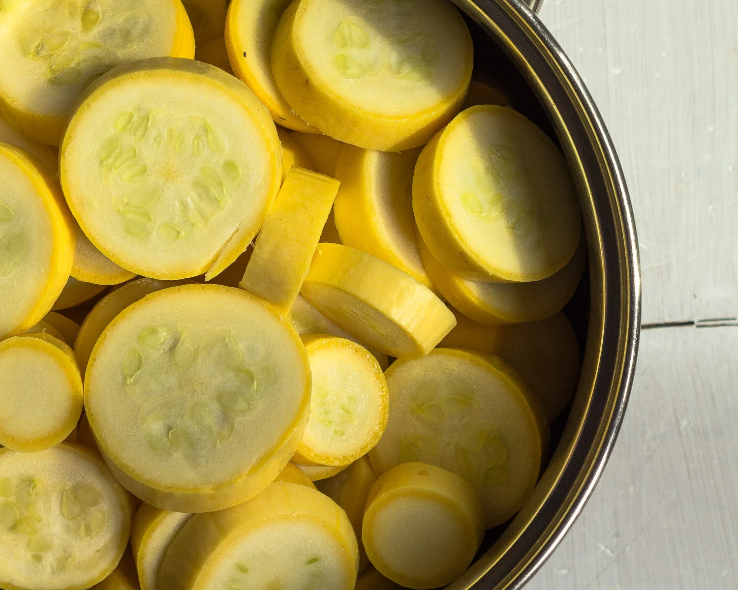 Sliced yellow crook neck squash ready to boil.