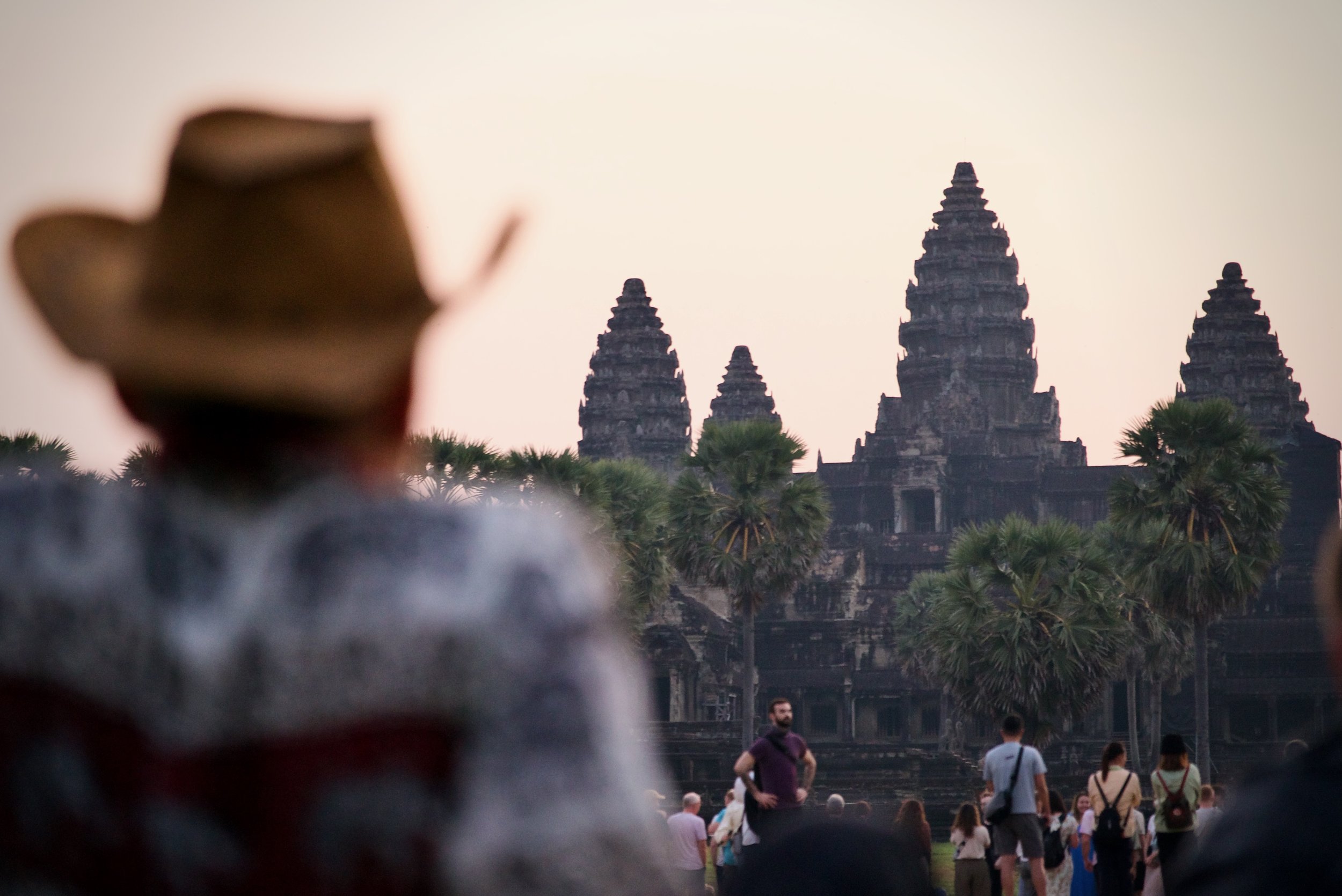 A tourist watches the sun rise behind Angkor Wat, Cambodia