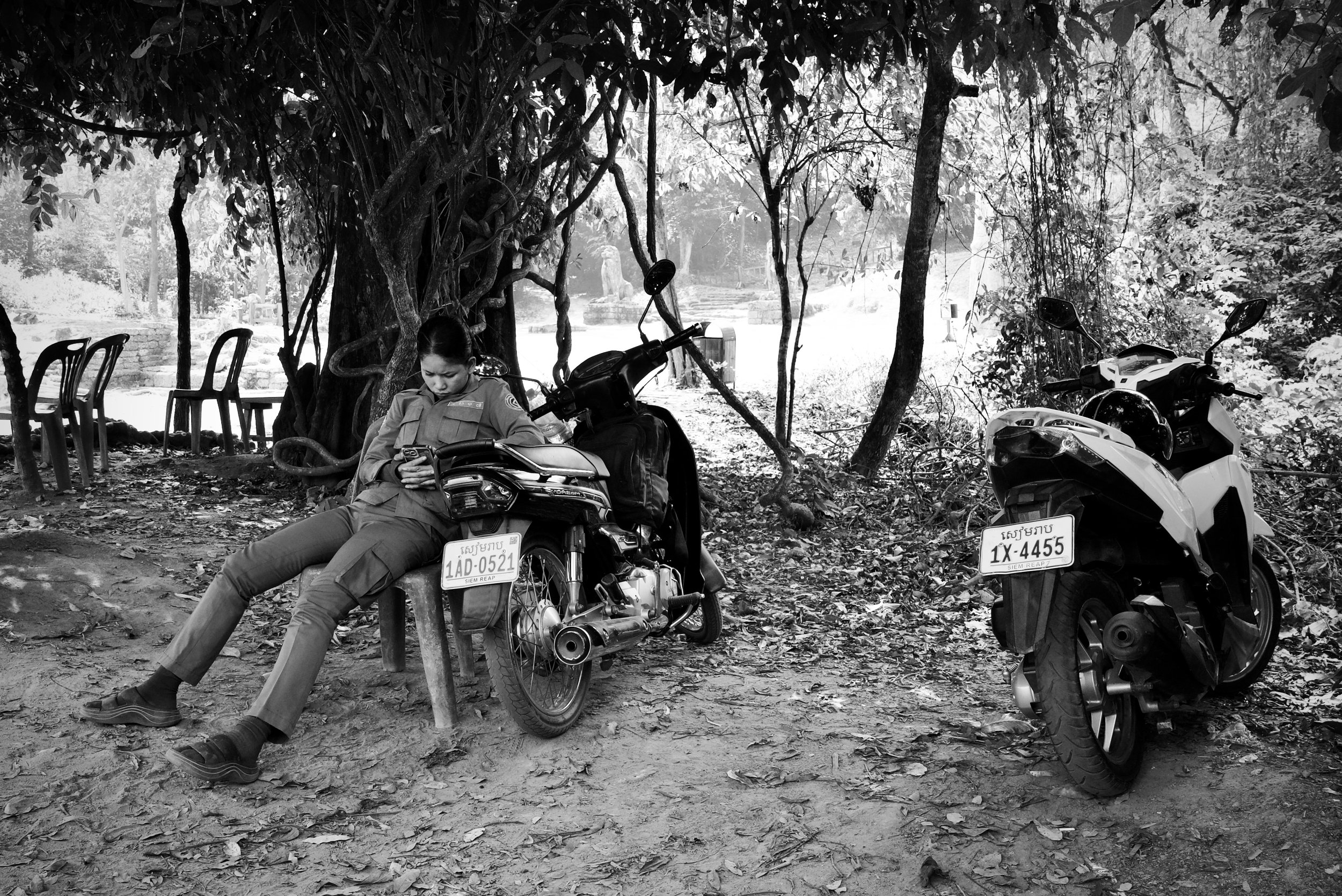A security guard plays on her phone, Angkor Wat, Cambodia