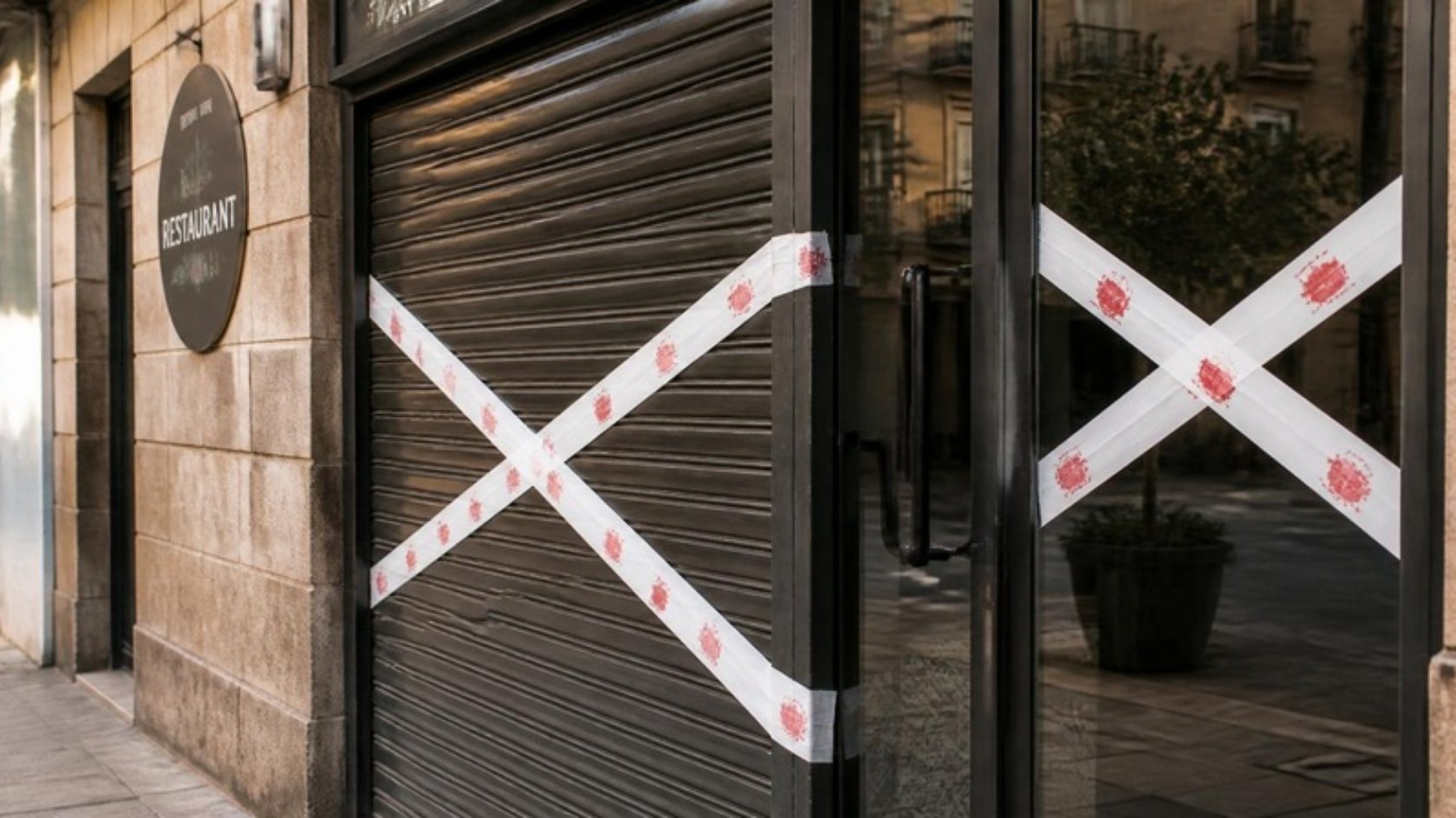 Fachada de un restaurante cerrado con sellos de clausura cruzados sobre la cortina y la puerta