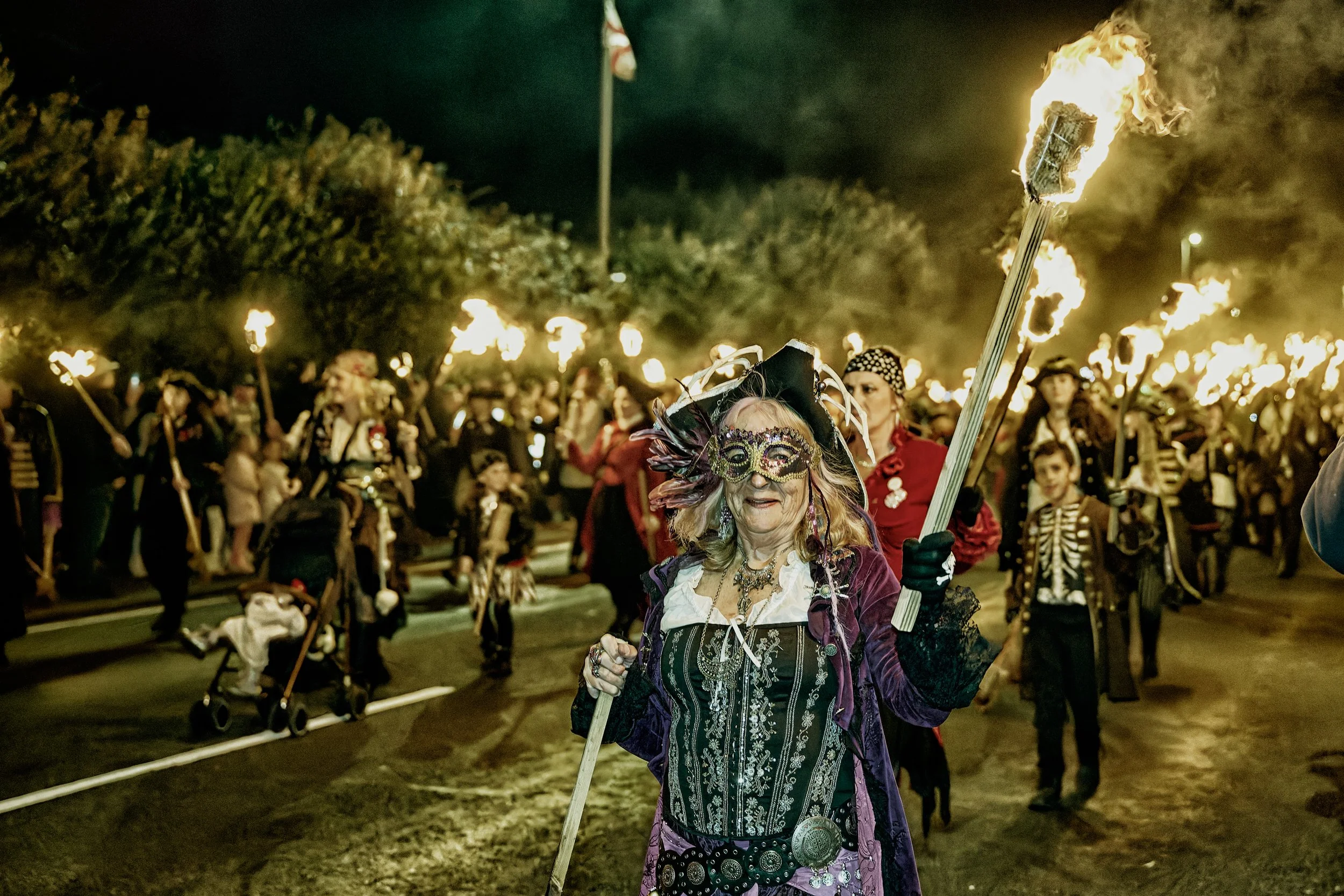 Documentary fieldwork photograph of a Sussex Bonfire Society parade in Seaford, showing Pirates carrying flaming torches