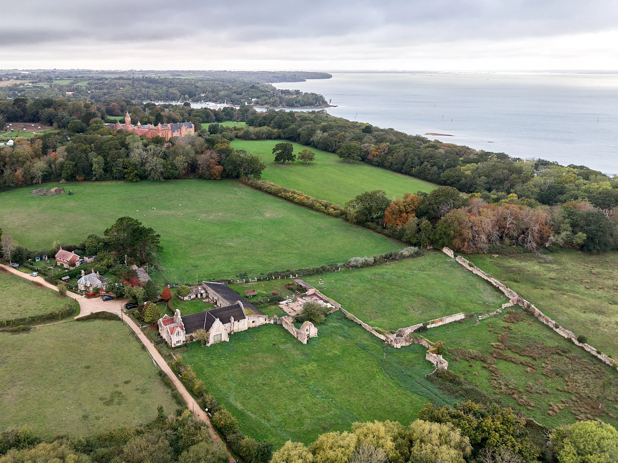 This documentary fieldwork photograph is of Medieval Quarr Abbey remains. The drone photograph shows ruins in the foreground, with Bellot’s New Quarr Abbey behind them. Its subject is continuity.