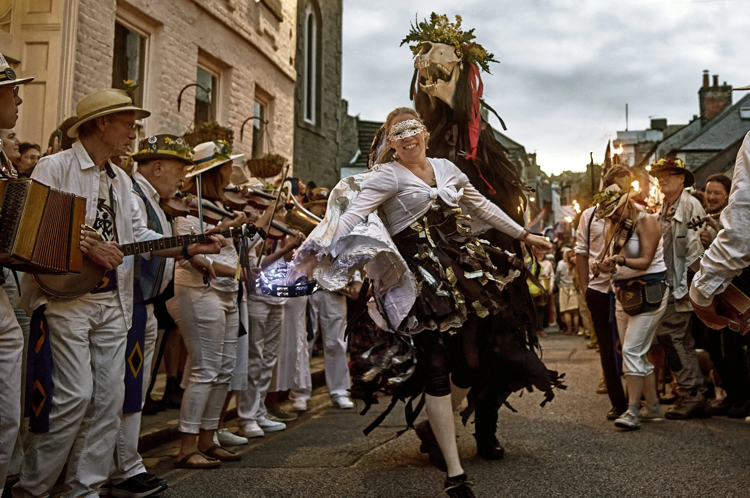 Documentary fieldwork photograph of Golowan Torch Lit parade in Penzance showing Penglaz and Trickster in energetic dance