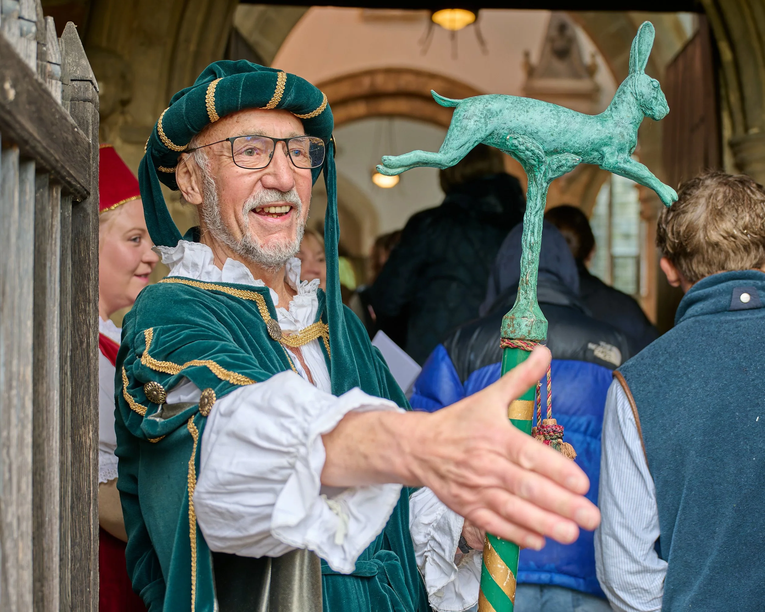 Documentary fieldwork photograph of the ancient Hare Pie and Bottle Kicking Event in Hallaton, showing the Warrener of Hares greeting guests