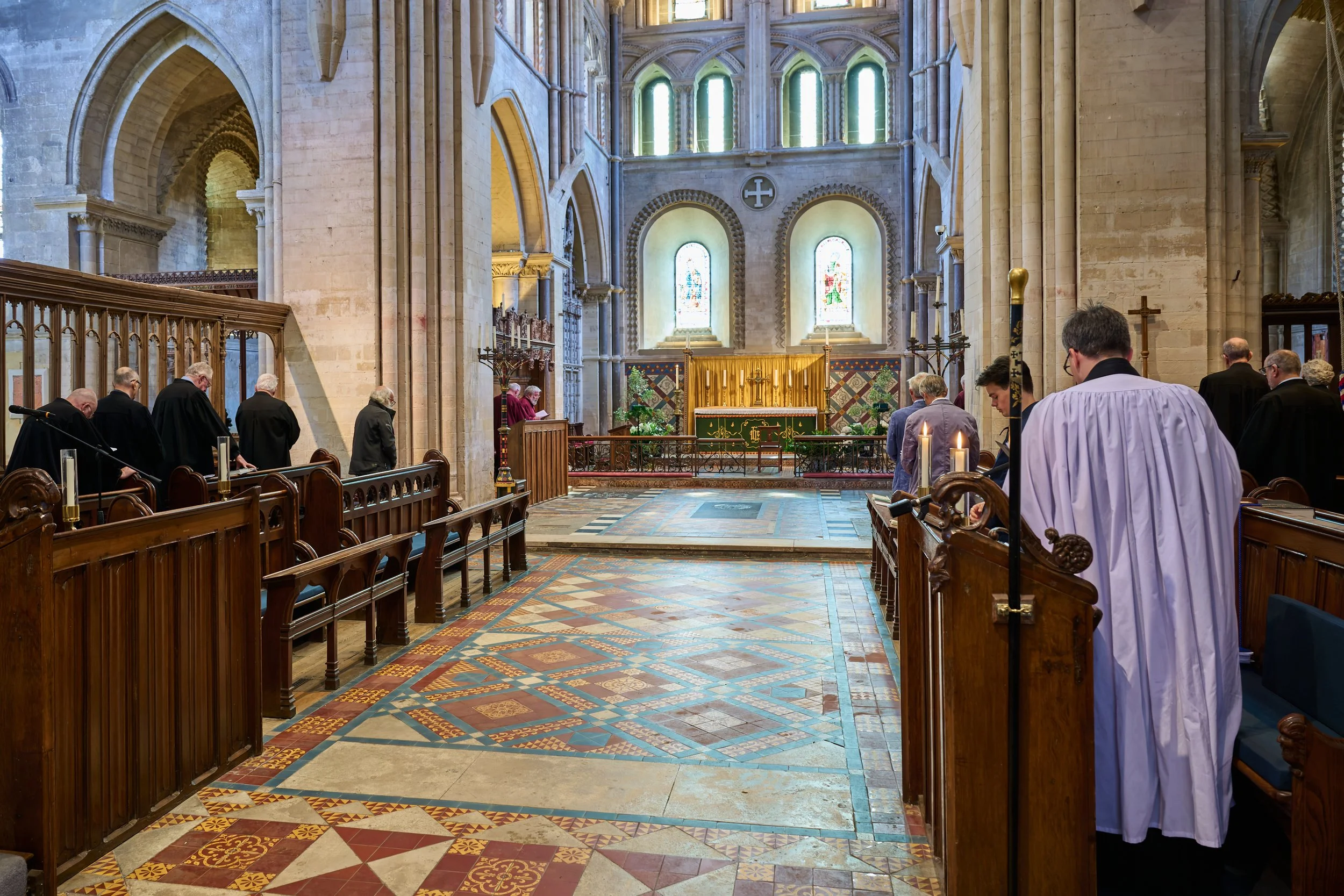 This documentary fieldwork photograph shows traditionally robed Brothers turning to face the Cross in a simple movement, made powerful by its precision and shared purpose, during a Matins service.