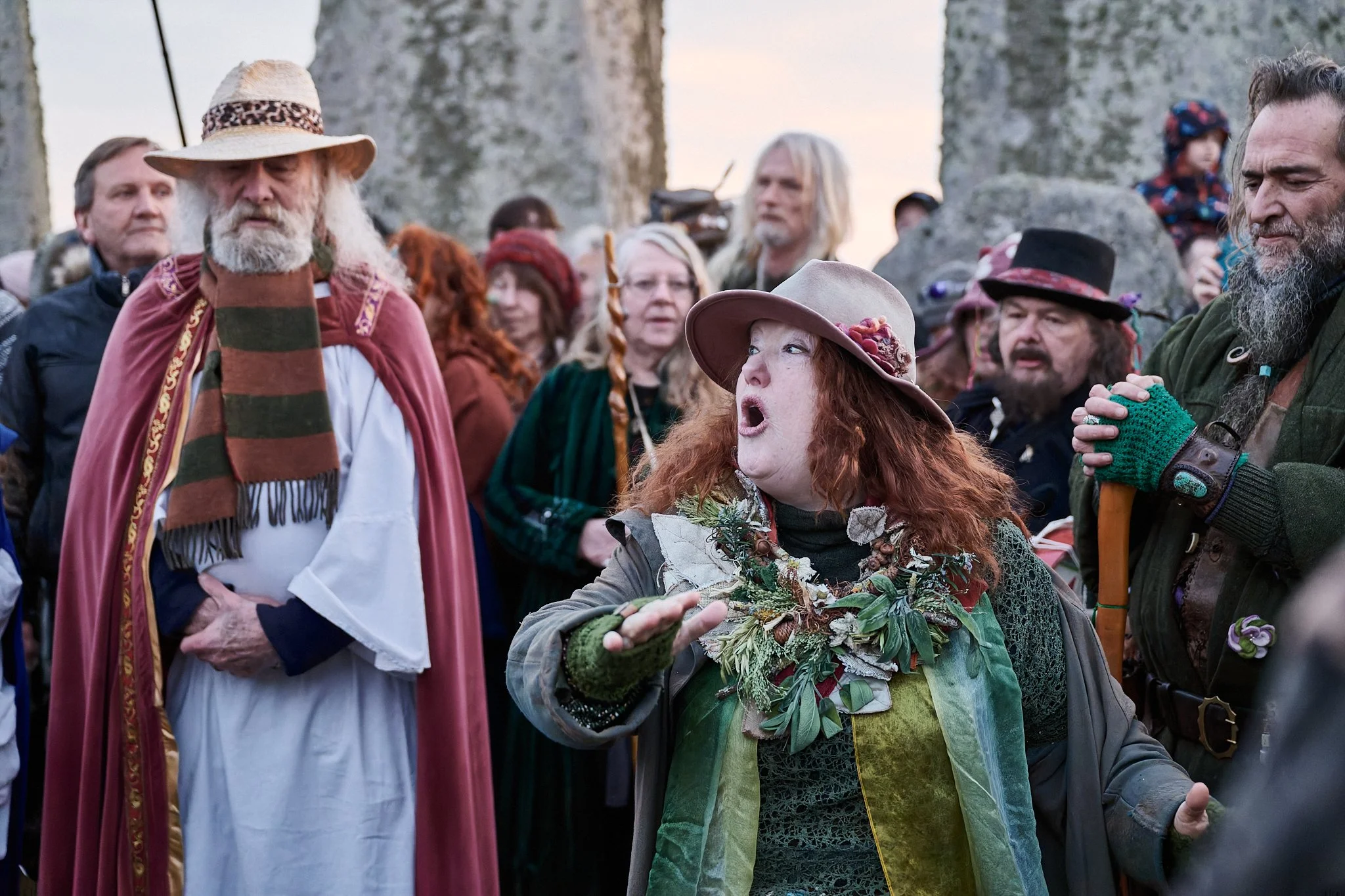 Documentary fieldwork photograph of Druids inside Stonehenge Stone Circle, showing spellbinding storytelling at the Spring Equinox sunrise