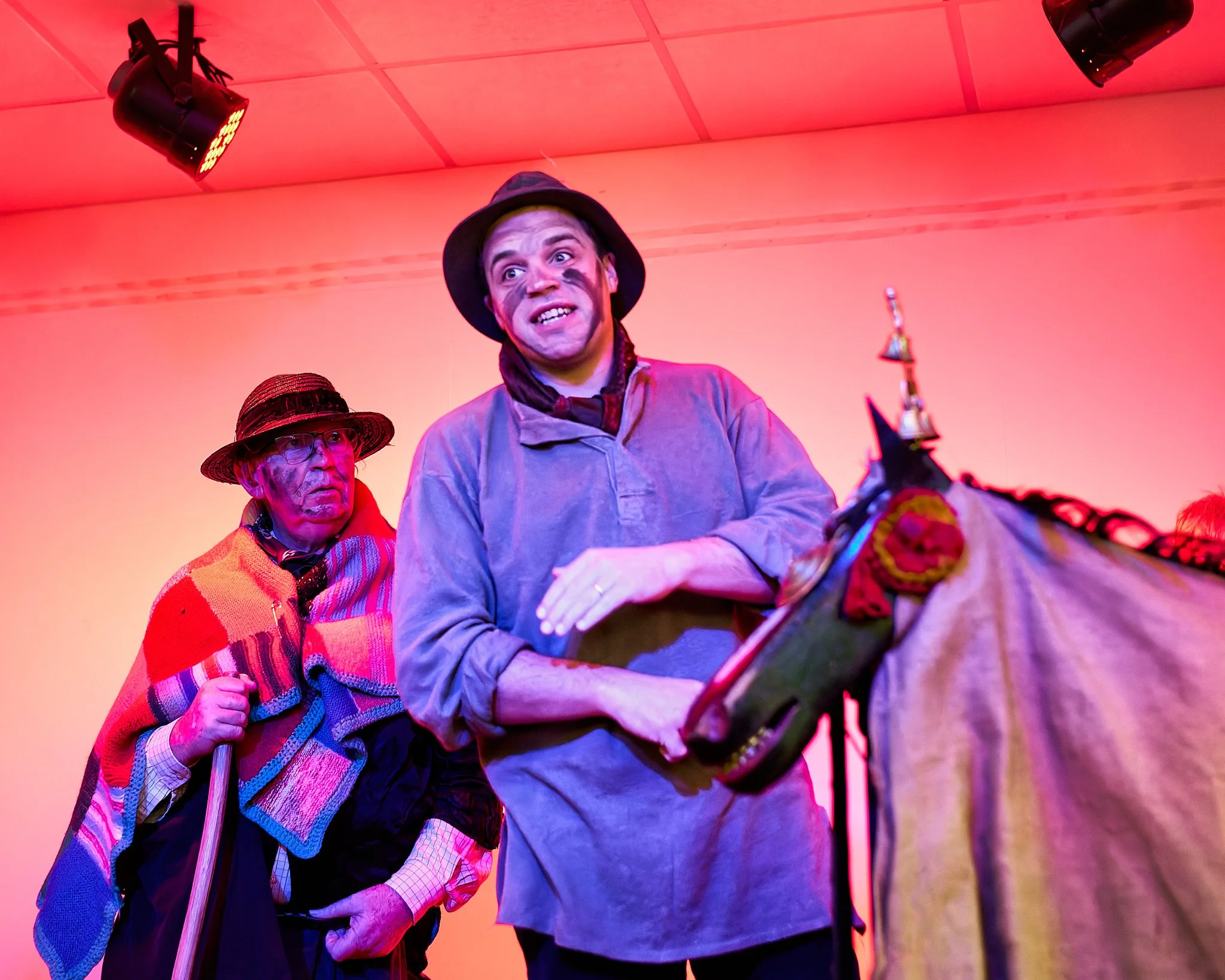 Documentary fieldwork photograph of The Hoodeners in Monkon Village Hall, showing The Farm Hand delivering lines