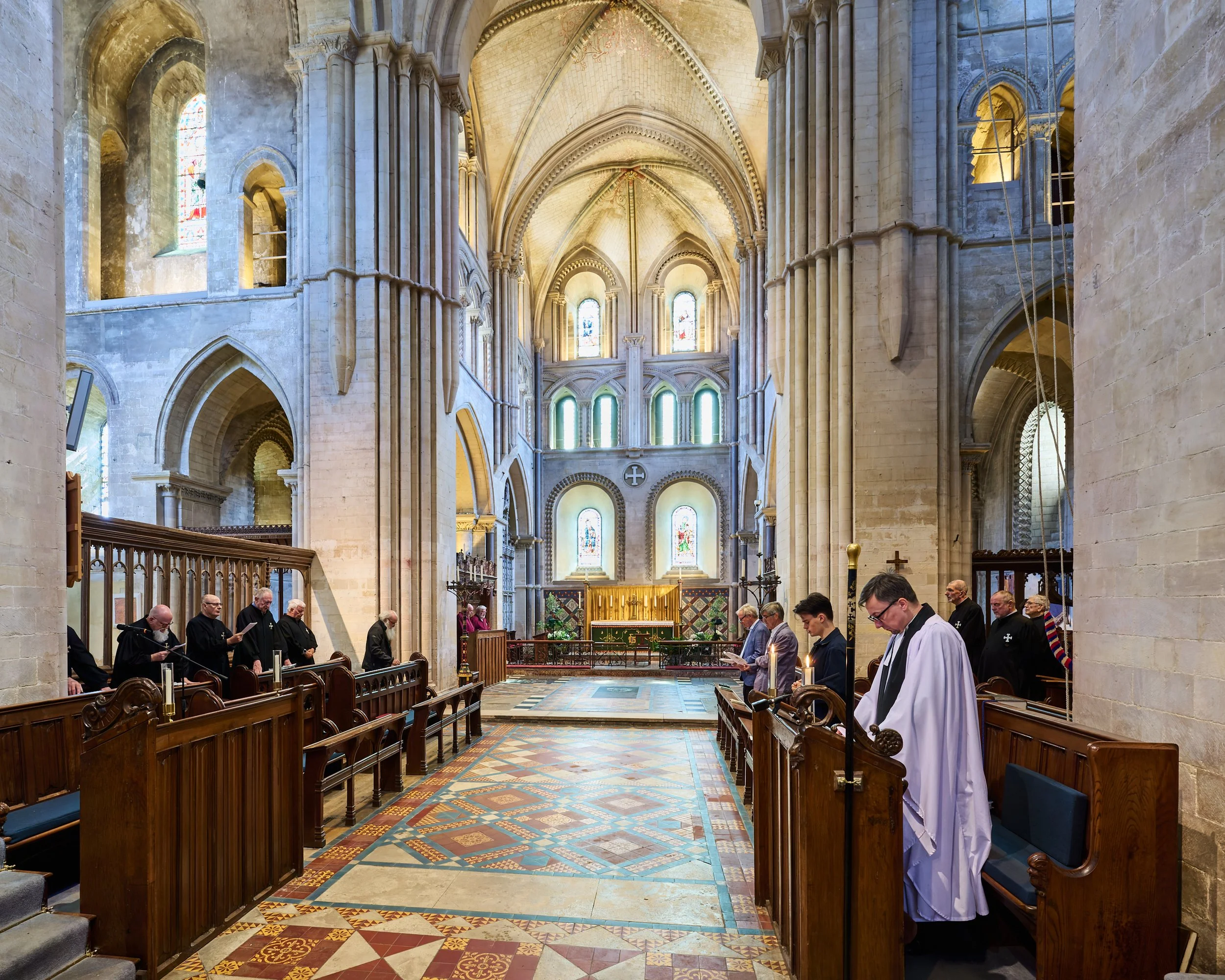 This documentary fieldwork photograph shows Black- and Red-traditionally robed Brothers inside Saint Cross Church during the morning Matins service.