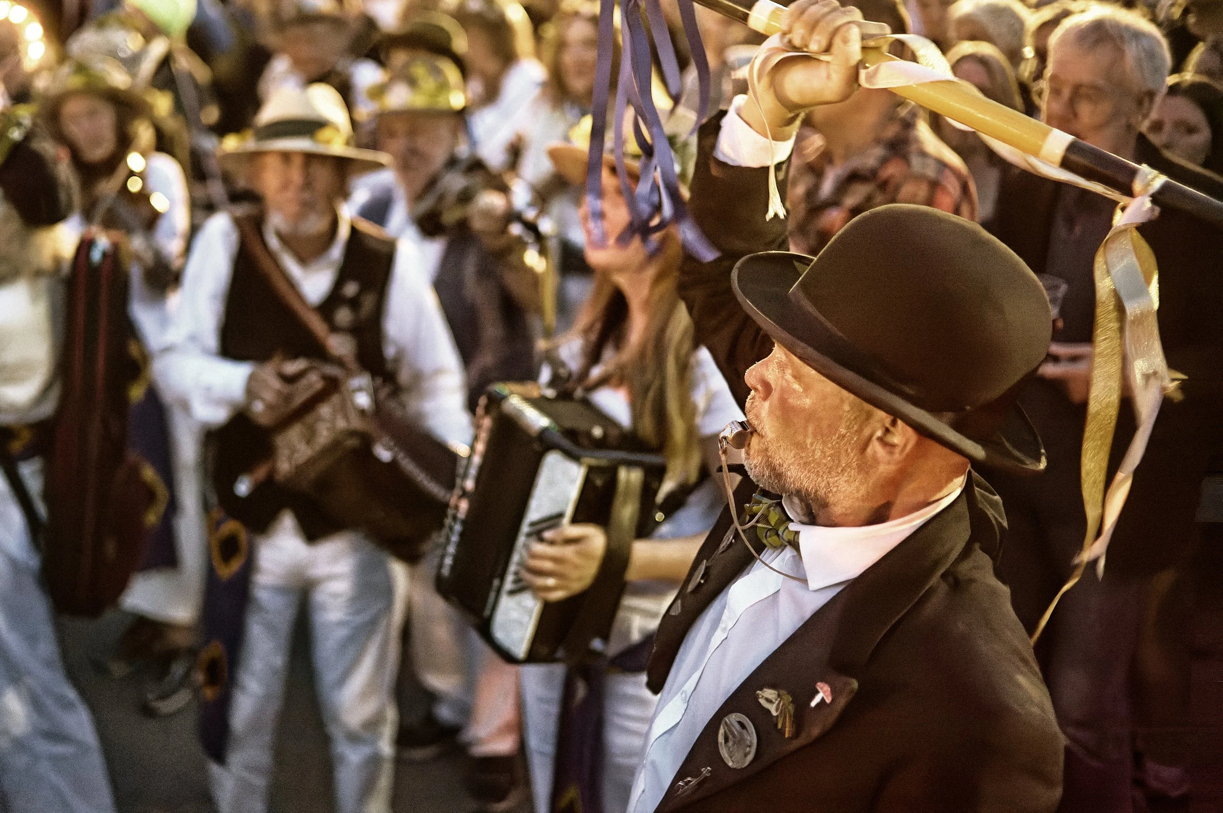 Documentary fieldwork photograph of Golowan Torch Lit parade in Penzance showing the Master of Ceremonies conducting the Band in bonfire heat