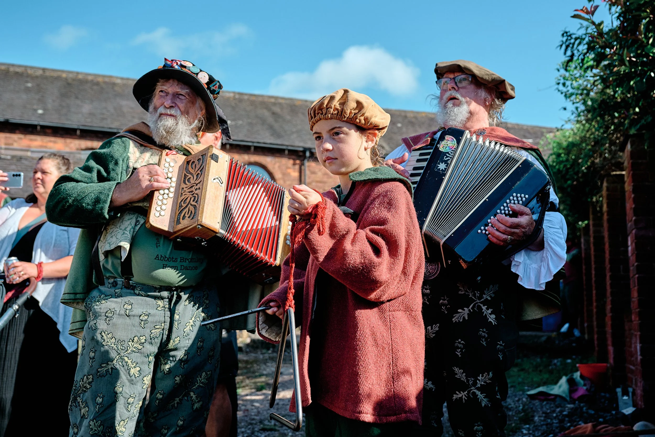 Documentary fieldwork photograph of the Horn Dance event in Abbots Bromley, showing the musicians and triangle keeping time